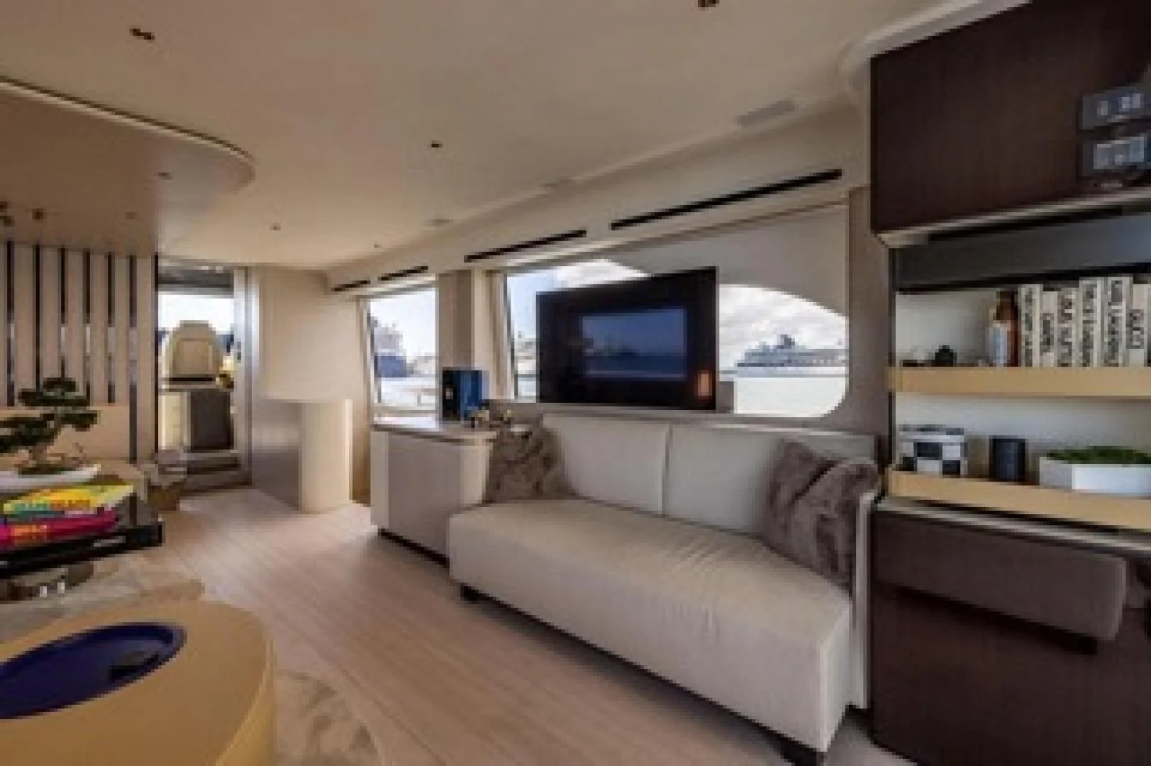 a living room with a large flat screen television and a bookcase aboard SUN LIFE Yacht for Sale