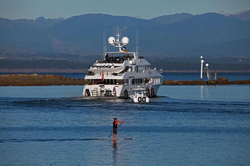 a person standing in the water next to a large ship aboard NO COMMENT Yacht for Sale
