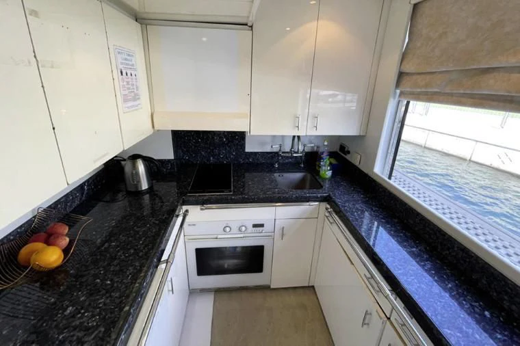 a kitchen with white cabinets aboard L'OR Yacht for Sale
