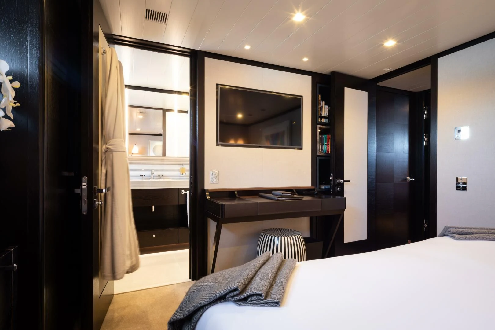 a bedroom with a bed and a television aboard MIRAGE Yacht for Sale
