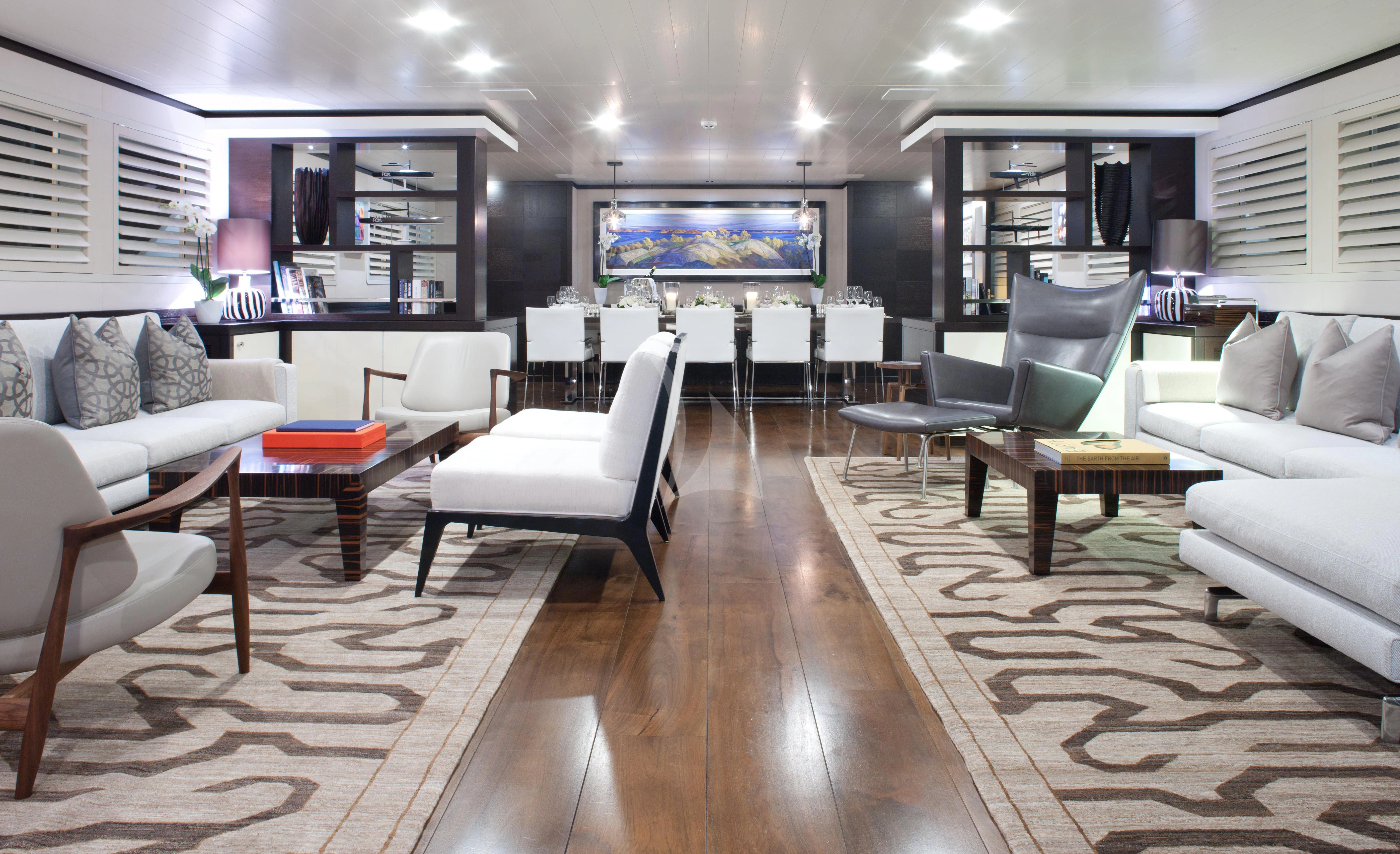 a room with a wood floor and white couches aboard MIRAGE Yacht for Sale
