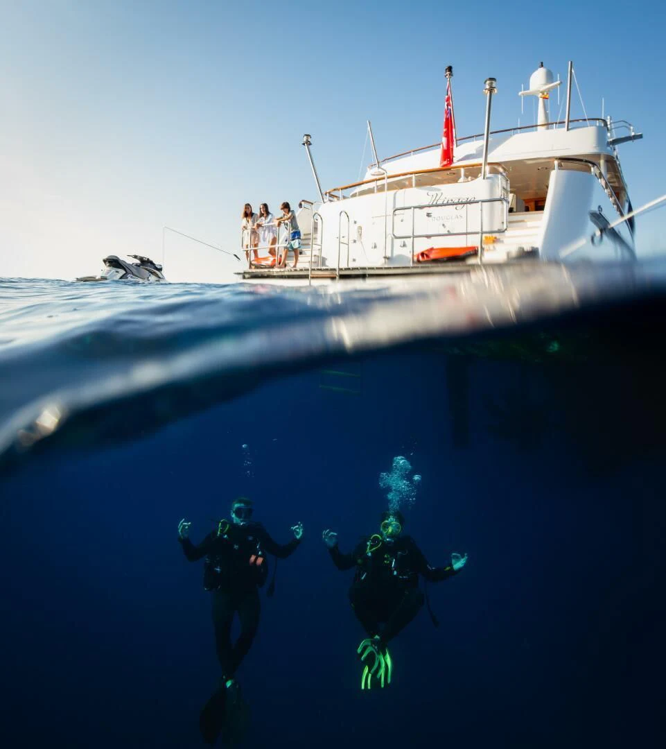 a group of people diving into a boat aboard MIRAGE Yacht for Sale