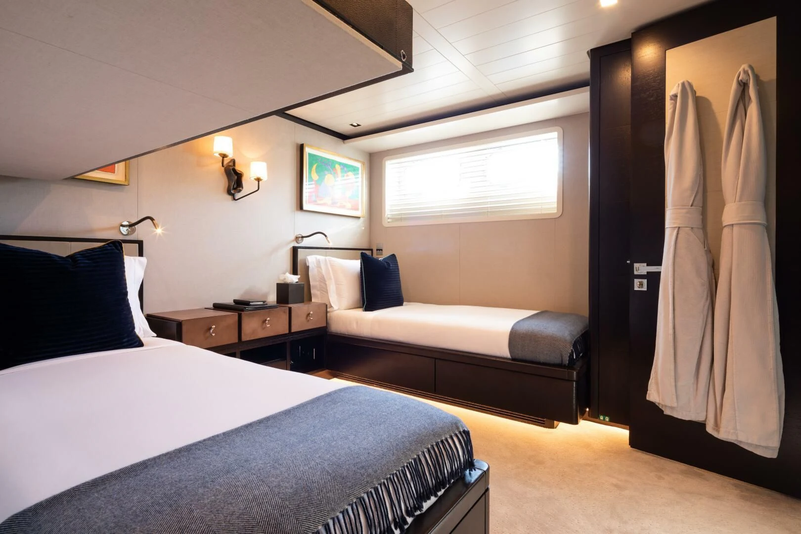a bedroom with a bed and a dresser aboard MIRAGE Yacht for Sale