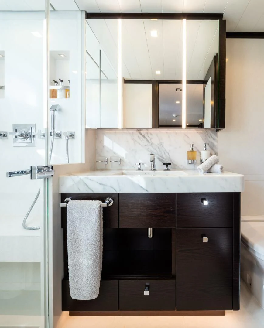 a white kitchen with black cabinets aboard MIRAGE Yacht for Sale