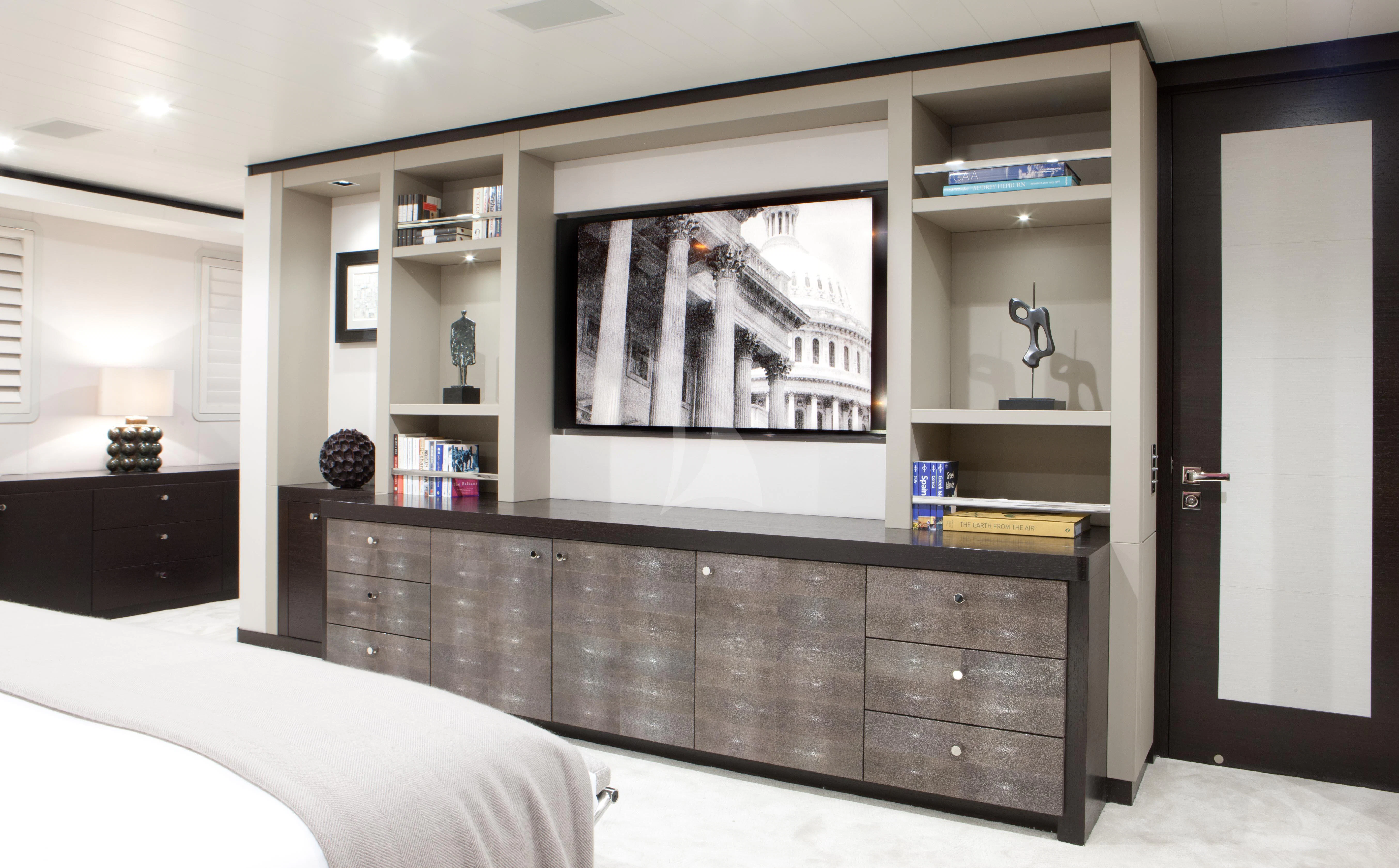 a room with a large mirror and a shelf with books on it aboard MIRAGE Yacht for Sale