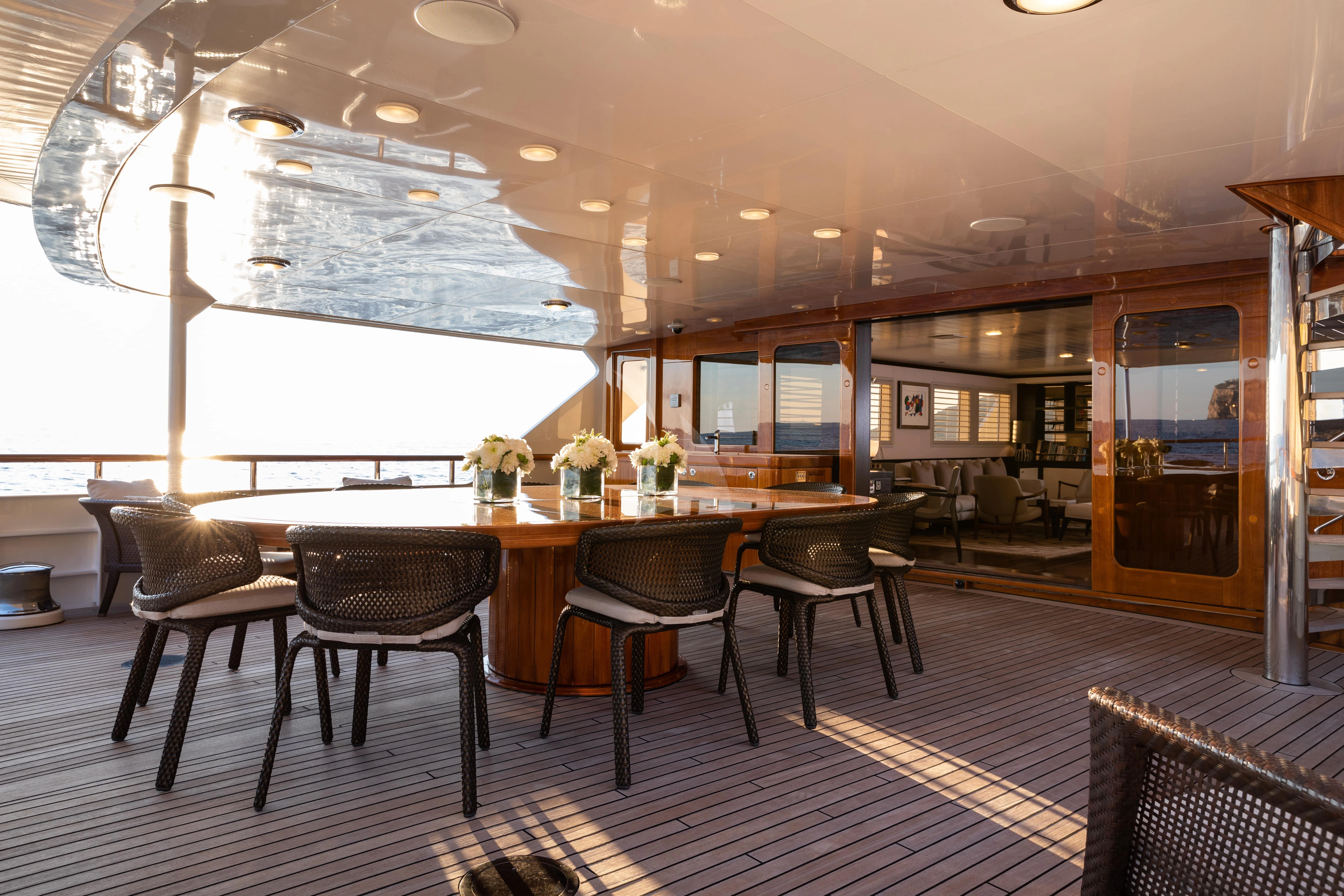 a large modern looking kitchen with a large table and chairs aboard MIRAGE Yacht for Sale