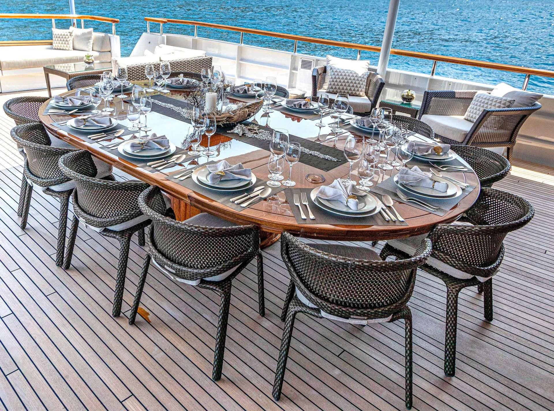 a table set for dinner on a deck aboard MIRAGE Yacht for Sale