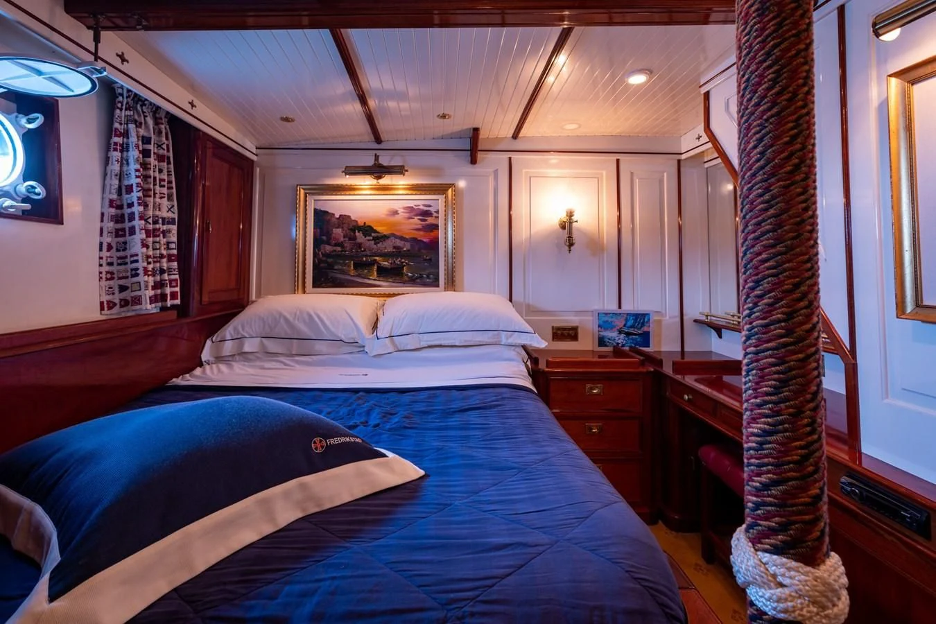 a bedroom with a bed and a television aboard FREDRIKSTAD Yacht for Sale