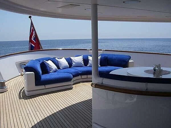 a couch and a table on a balcony overlooking a beach aboard CLEOPATRA Yacht for Sale