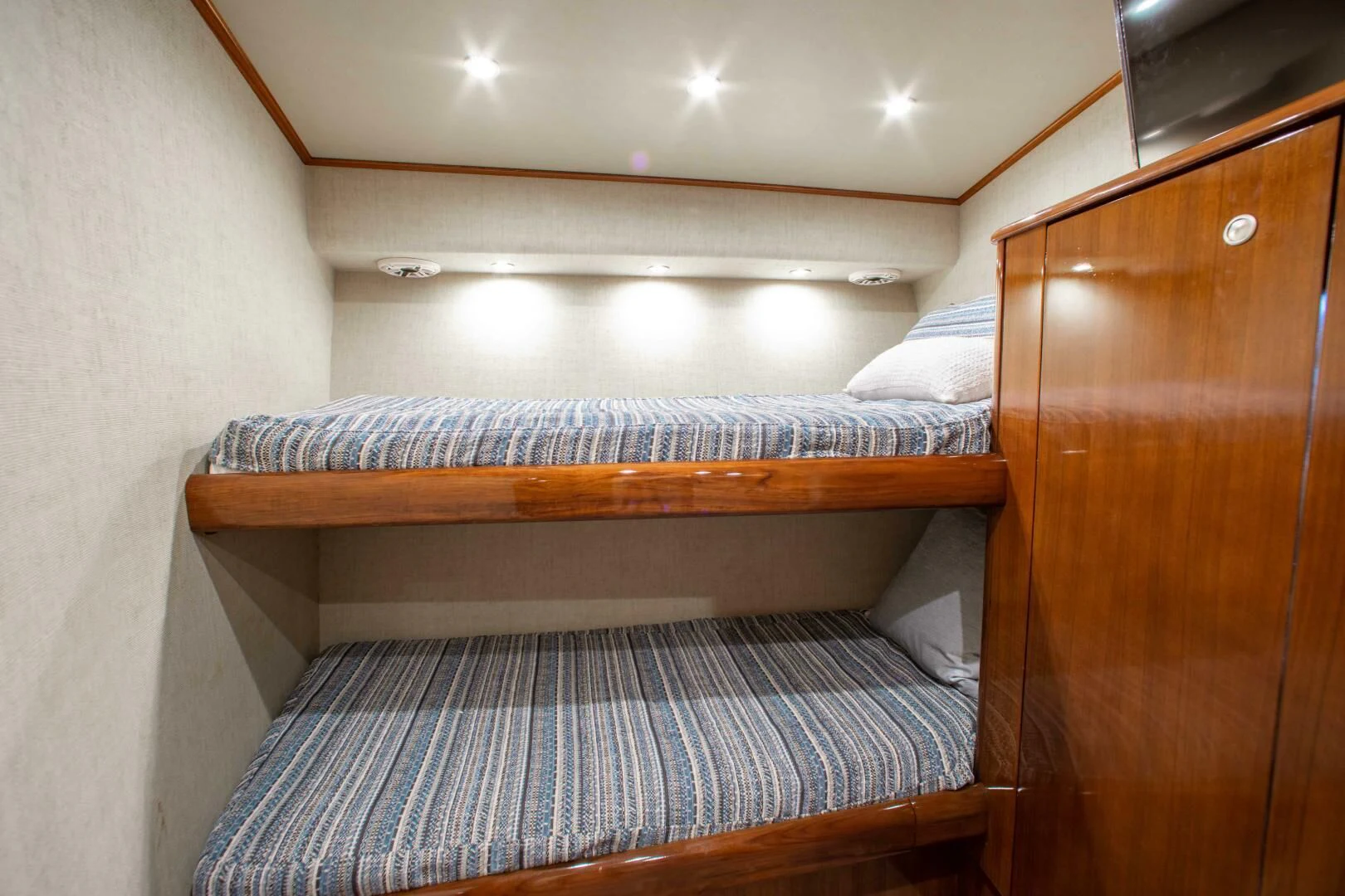 a bed with a wooden headboard aboard CURIOUS GEORGE Yacht for Sale