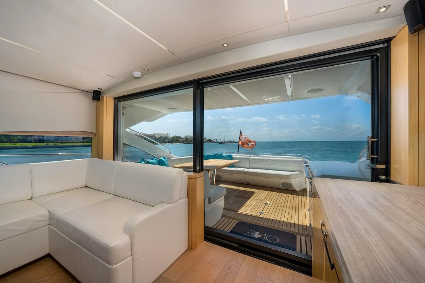 a room with a couch and a table and a large window aboard SUNSEEKER PREDATOR 68 Yacht for Sale