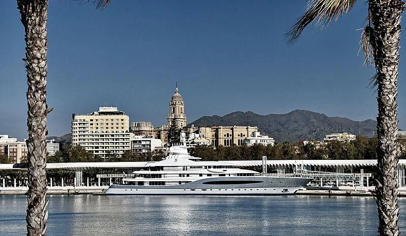 a large white boat in a body of water with a city in the background aboard MAYAN QUEEN IV Yacht for Sale