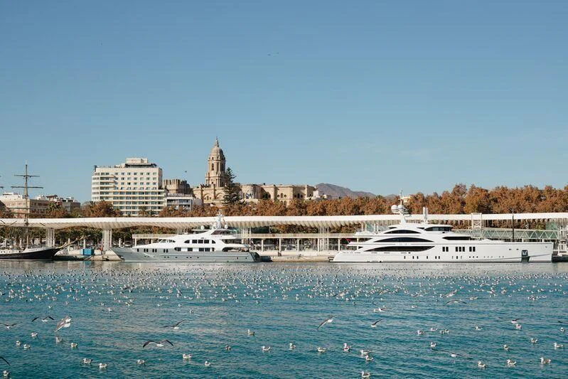 a body of water with boats and buildings in the background aboard AQUA MARE Yacht for Sale