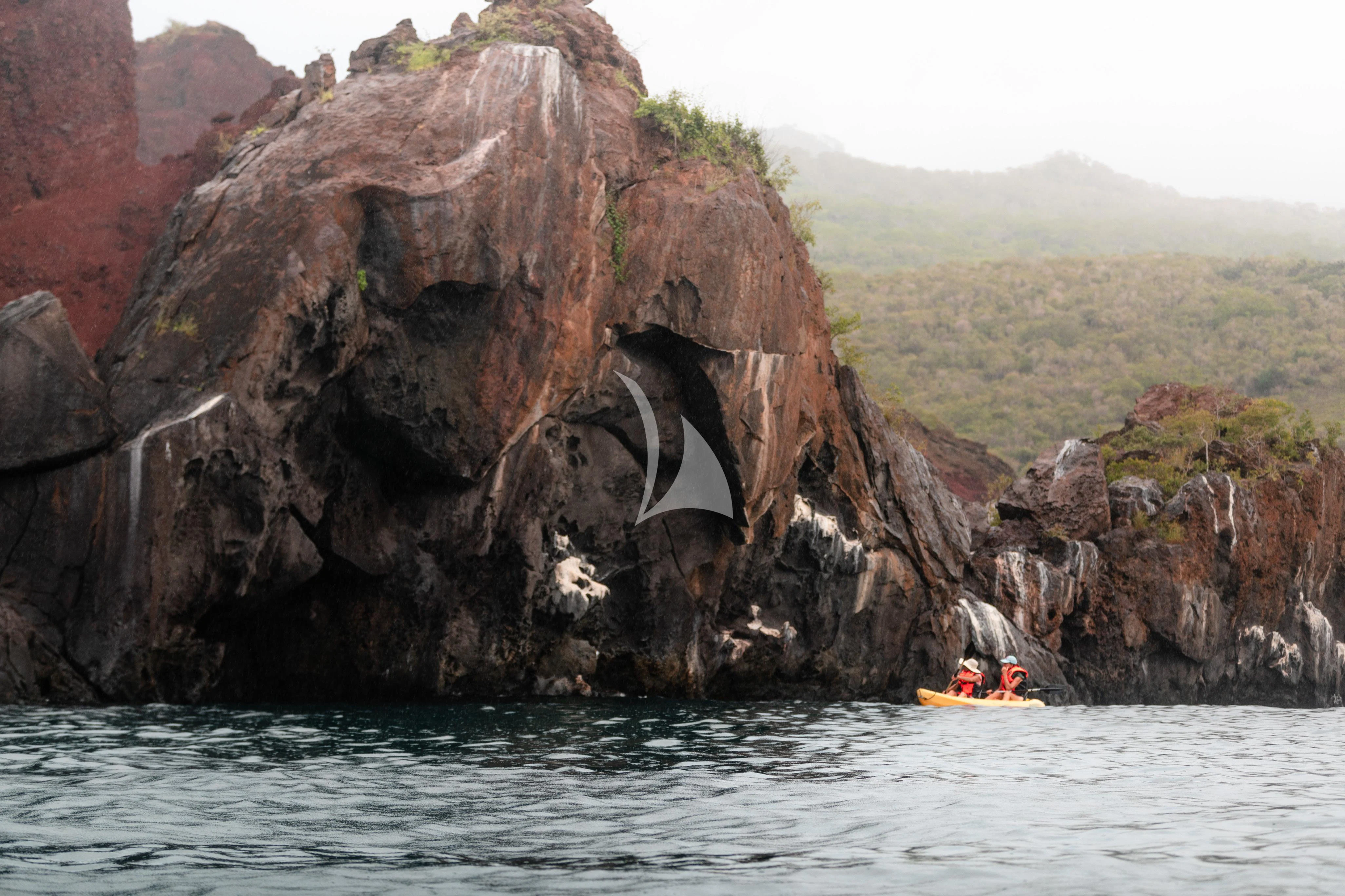 a person in a raft in a river with a large rock formation aboard AQUA MARE Yacht for Sale