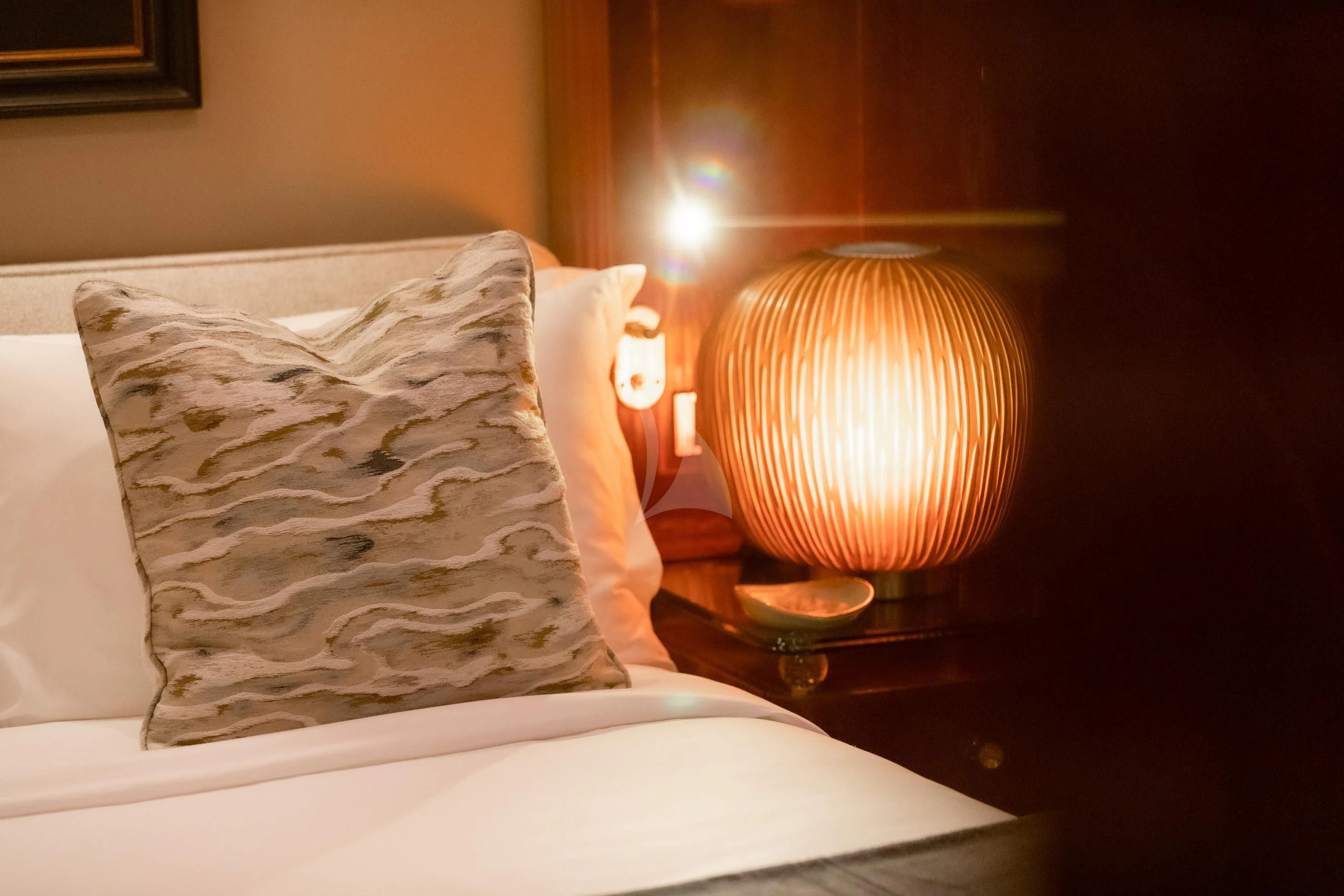 a bed with a white sheet and a lamp on it aboard AQUA MARE Yacht for Sale