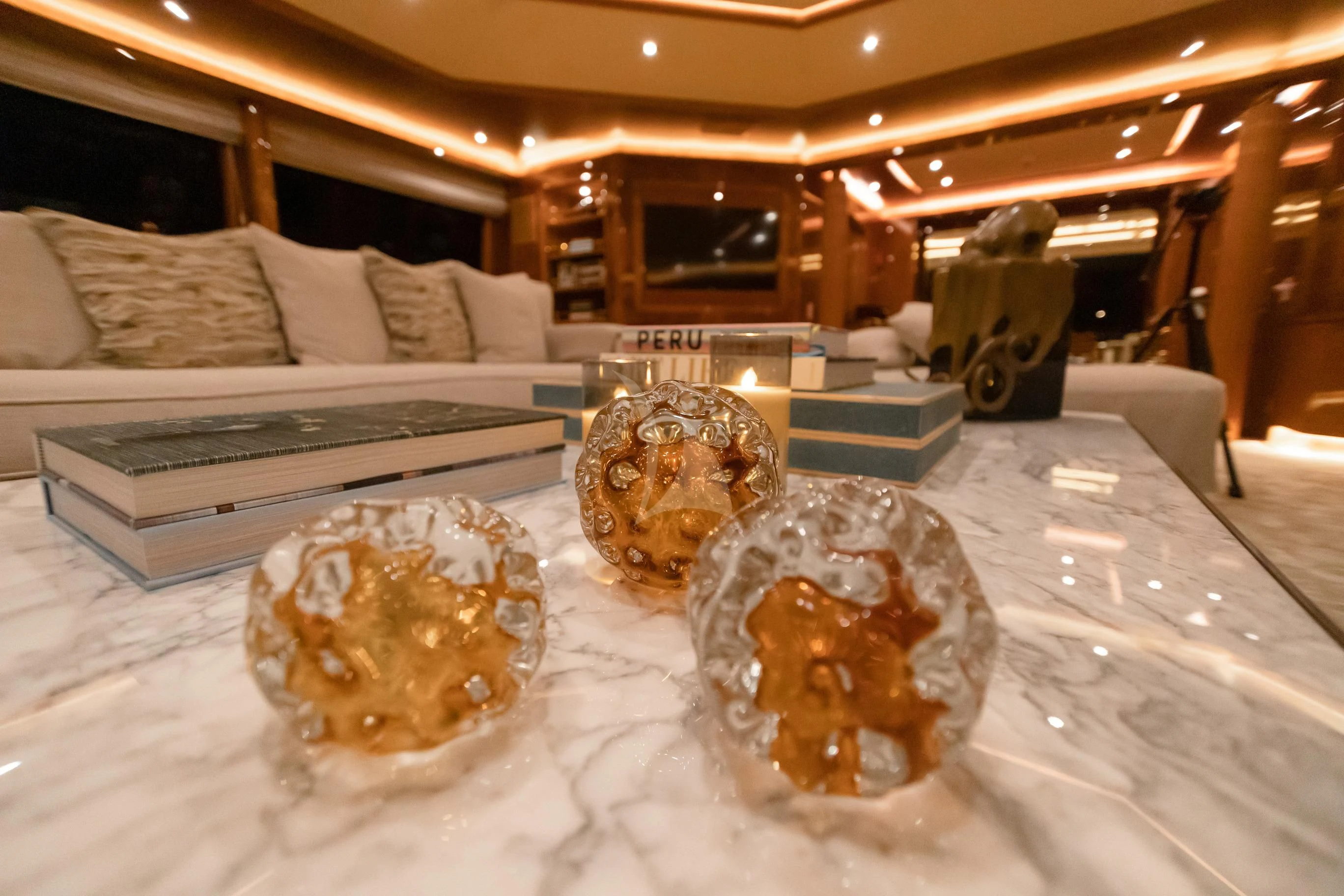 a room with a couch and a table with a large gold plate aboard AQUA MARE Yacht for Sale