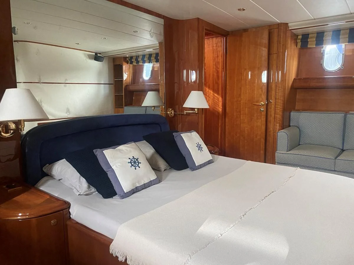 a bed with blue sheets and pillows aboard AMADEUS Yacht for Sale