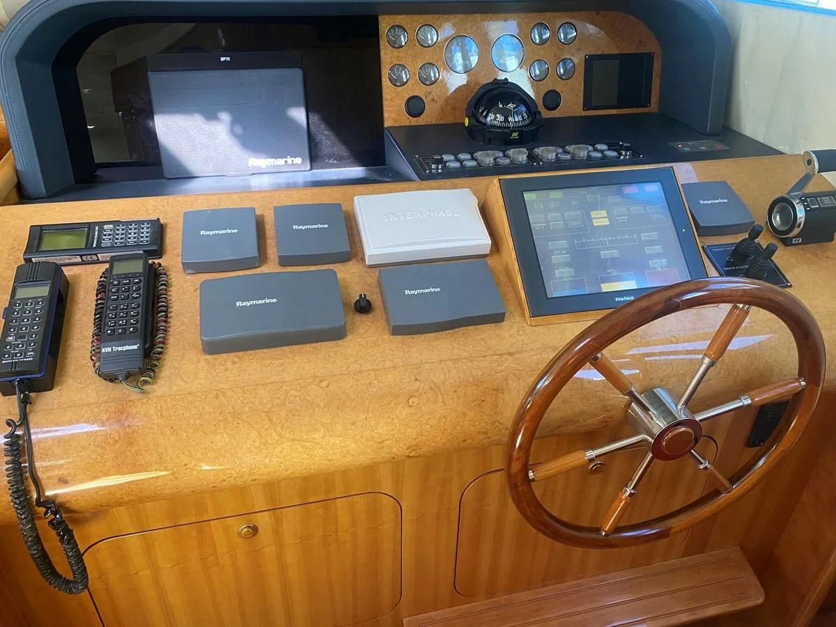 a wooden table with a radio and other electronics on it aboard AMADEUS Yacht for Sale