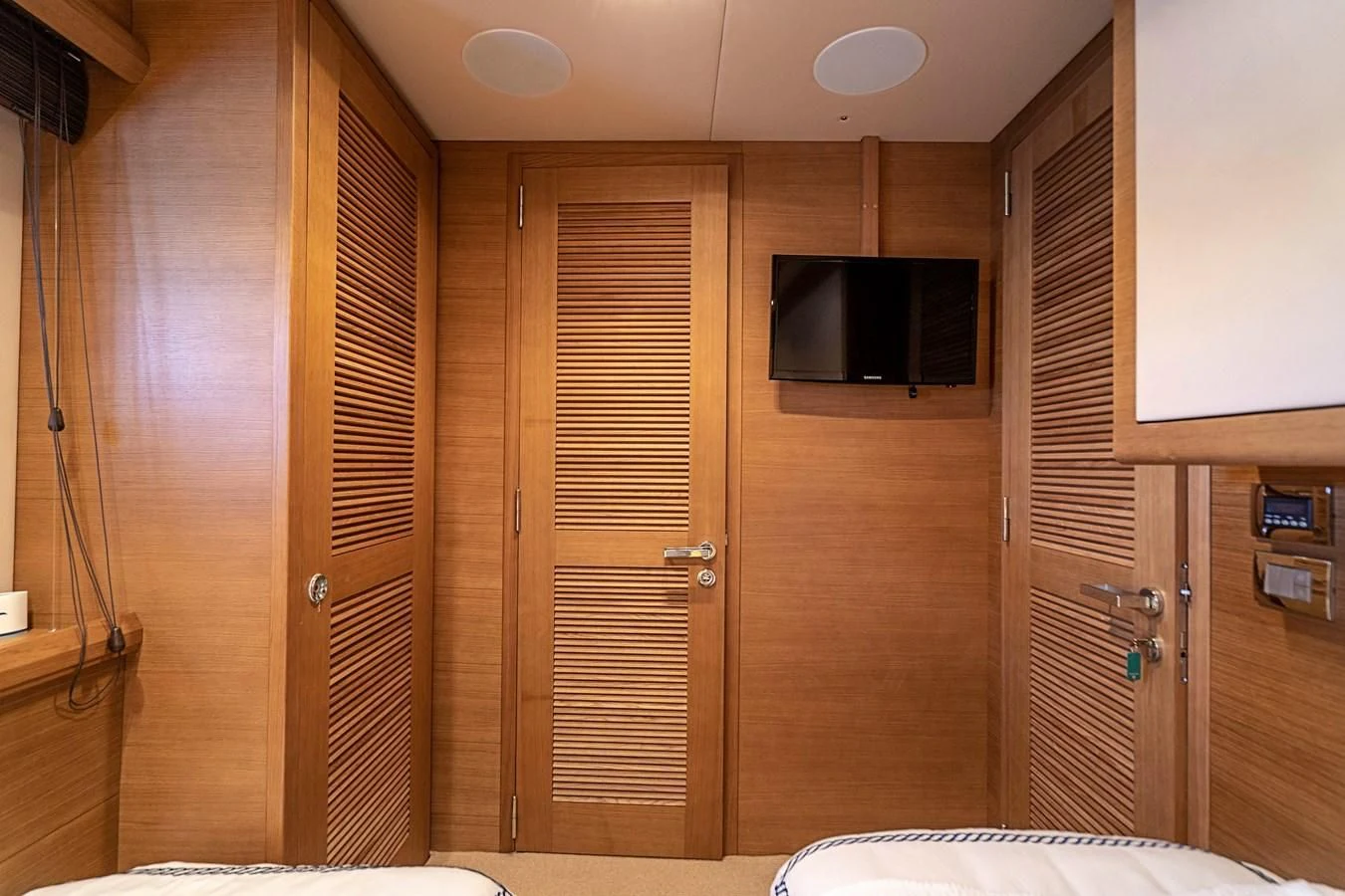 a room with a wood door and a television on the wall aboard INTERVENTION Yacht for Sale