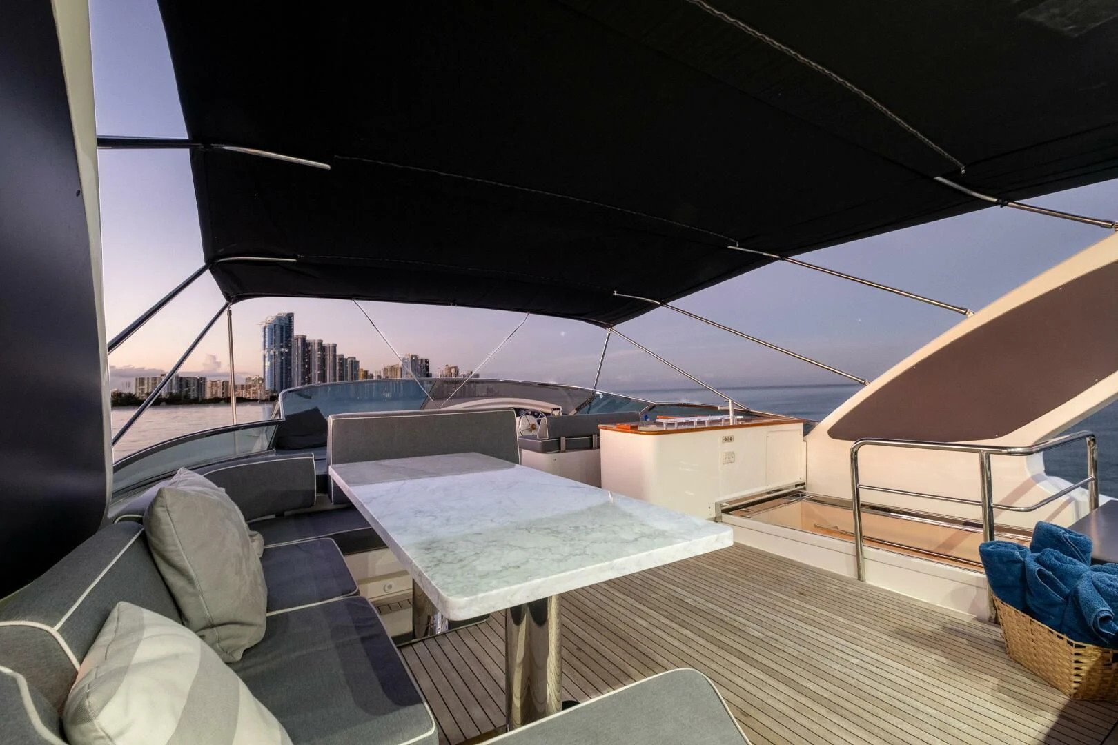 a large outdoor patio with a large white roof and a city in the background aboard INTERVENTION Yacht for Sale