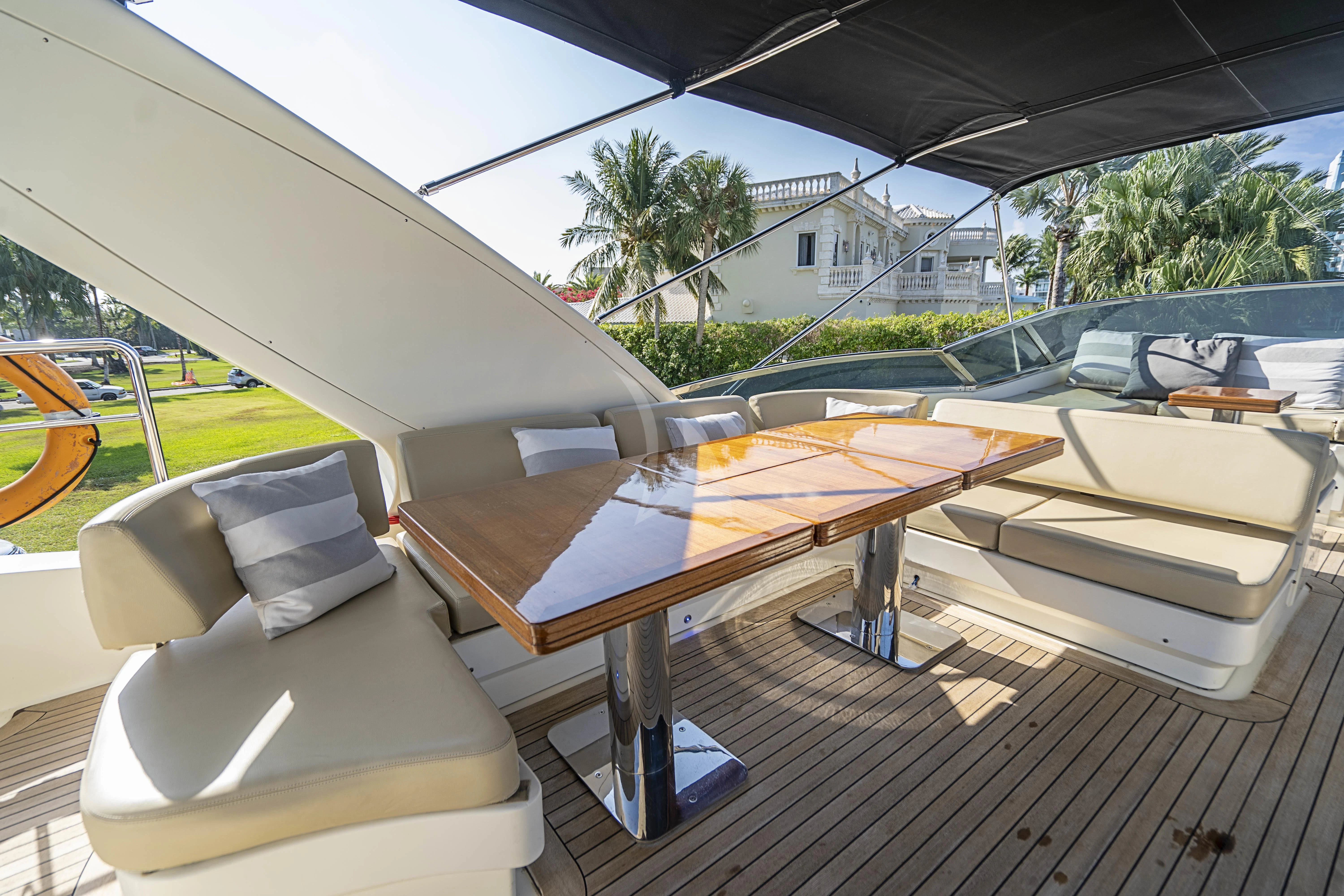 a table with chairs and a umbrella aboard INTERVENTION Yacht for Sale