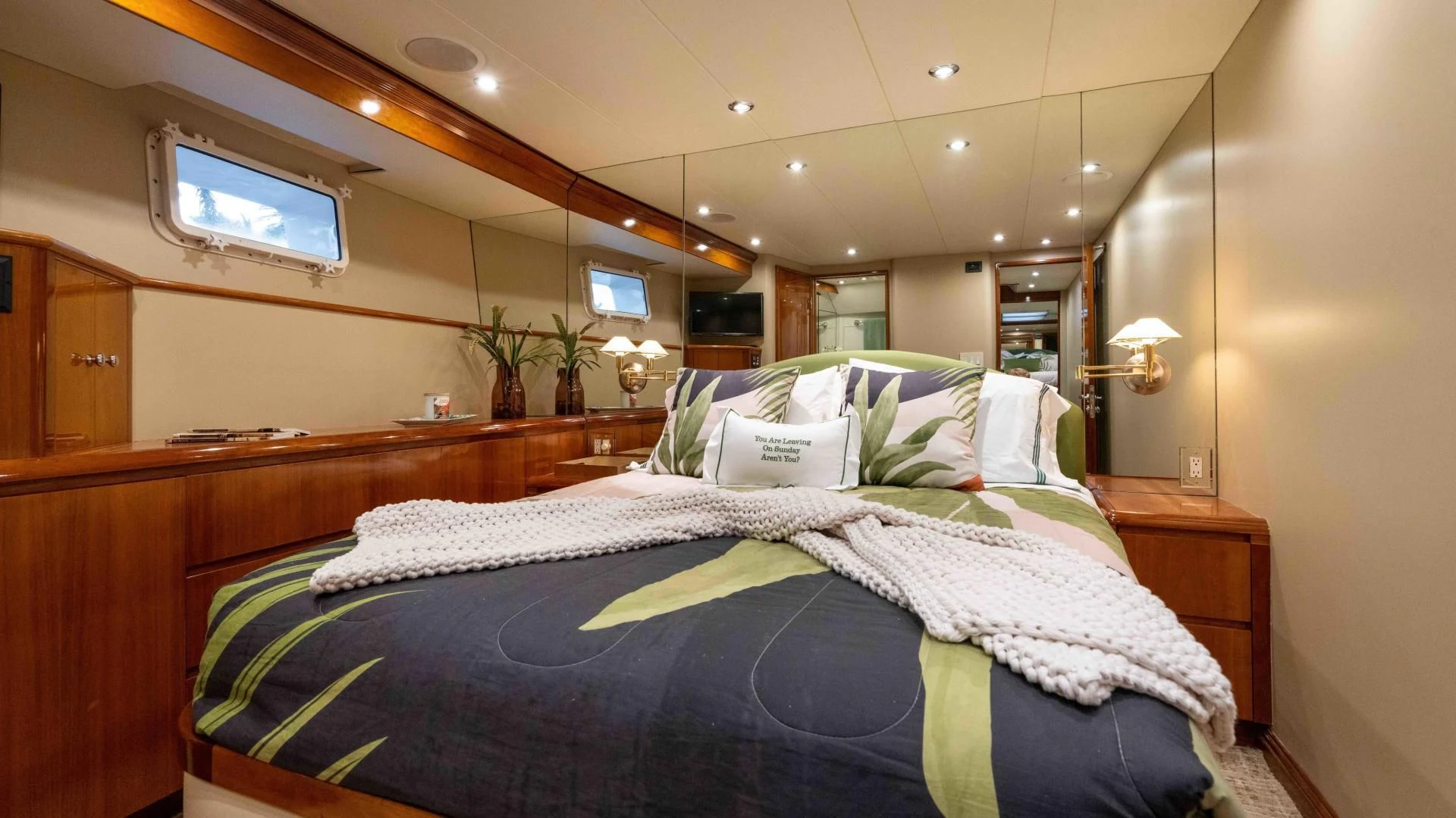 a bedroom with a bed and a television on the wall aboard WELL DONE Yacht for Sale