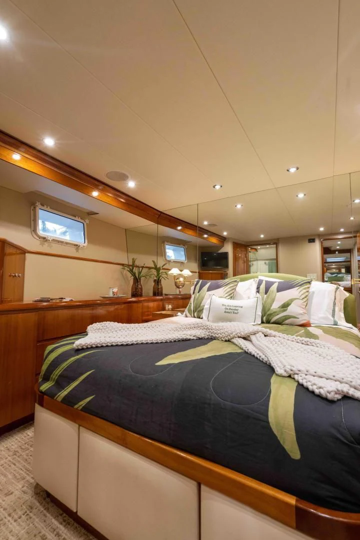 a bed with a blue comforter aboard WELL DONE Yacht for Sale