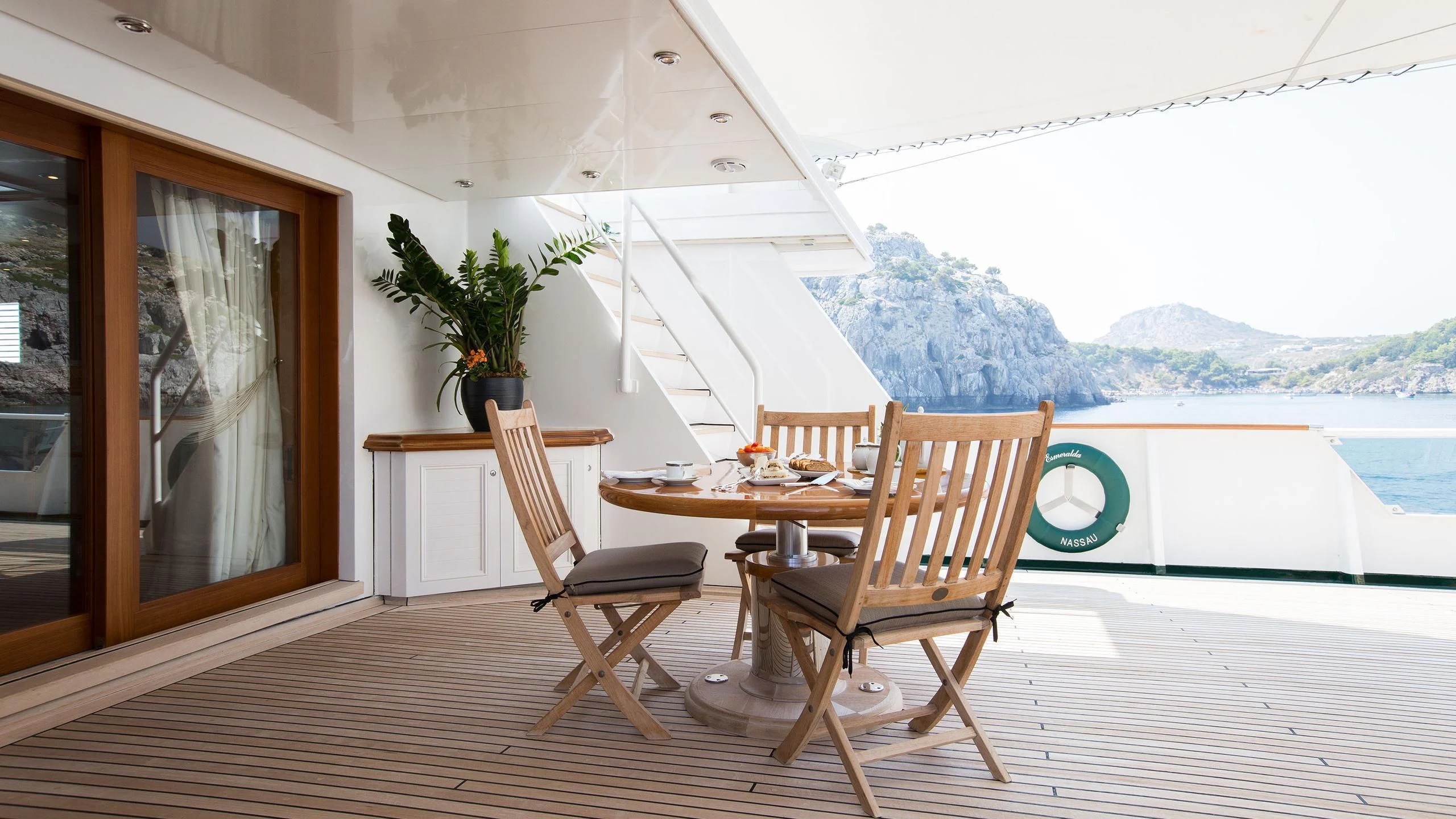 a table and chairs on a deck aboard ESMERALDA Yacht for Sale