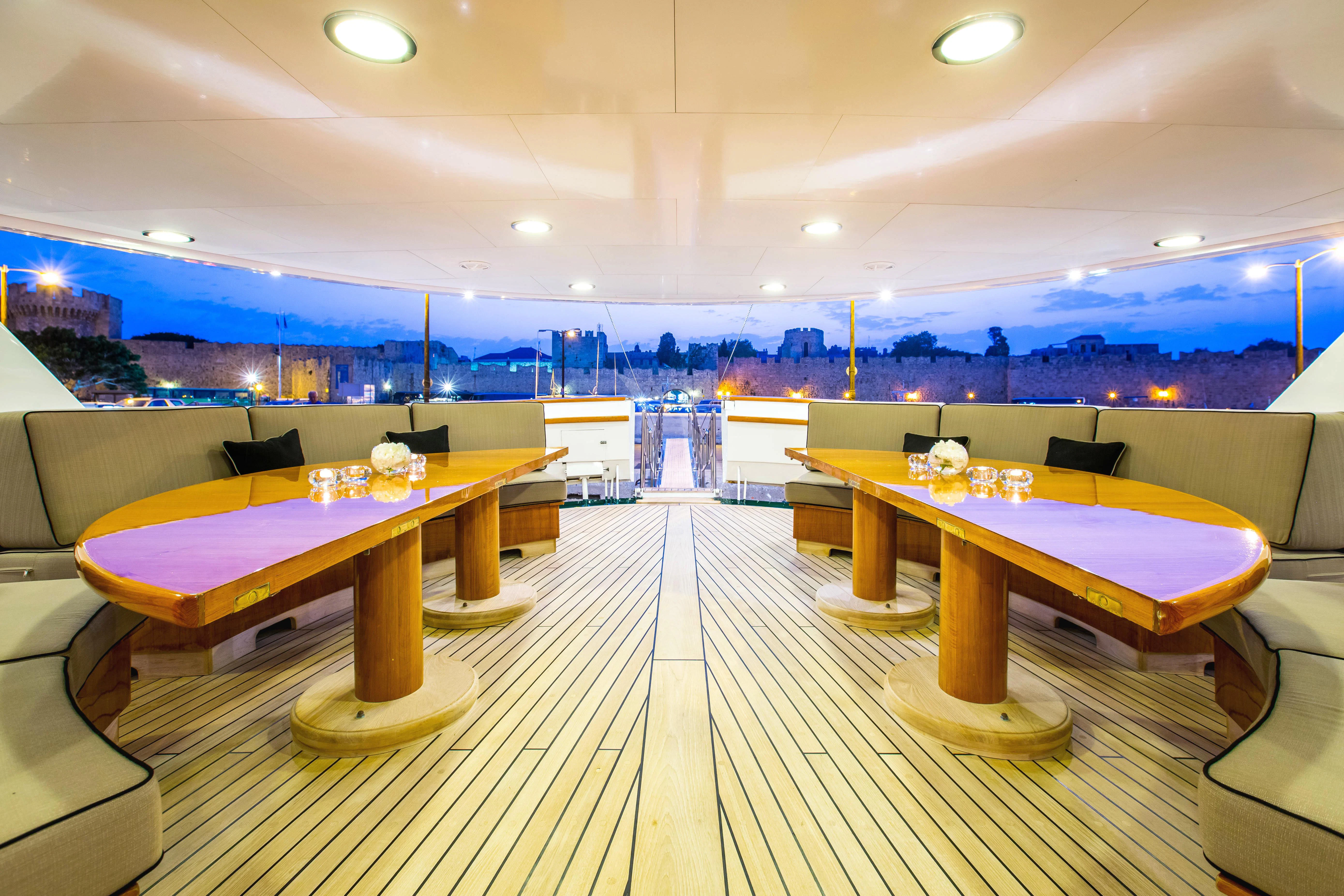 a room with tables and chairs aboard ESMERALDA Yacht for Sale