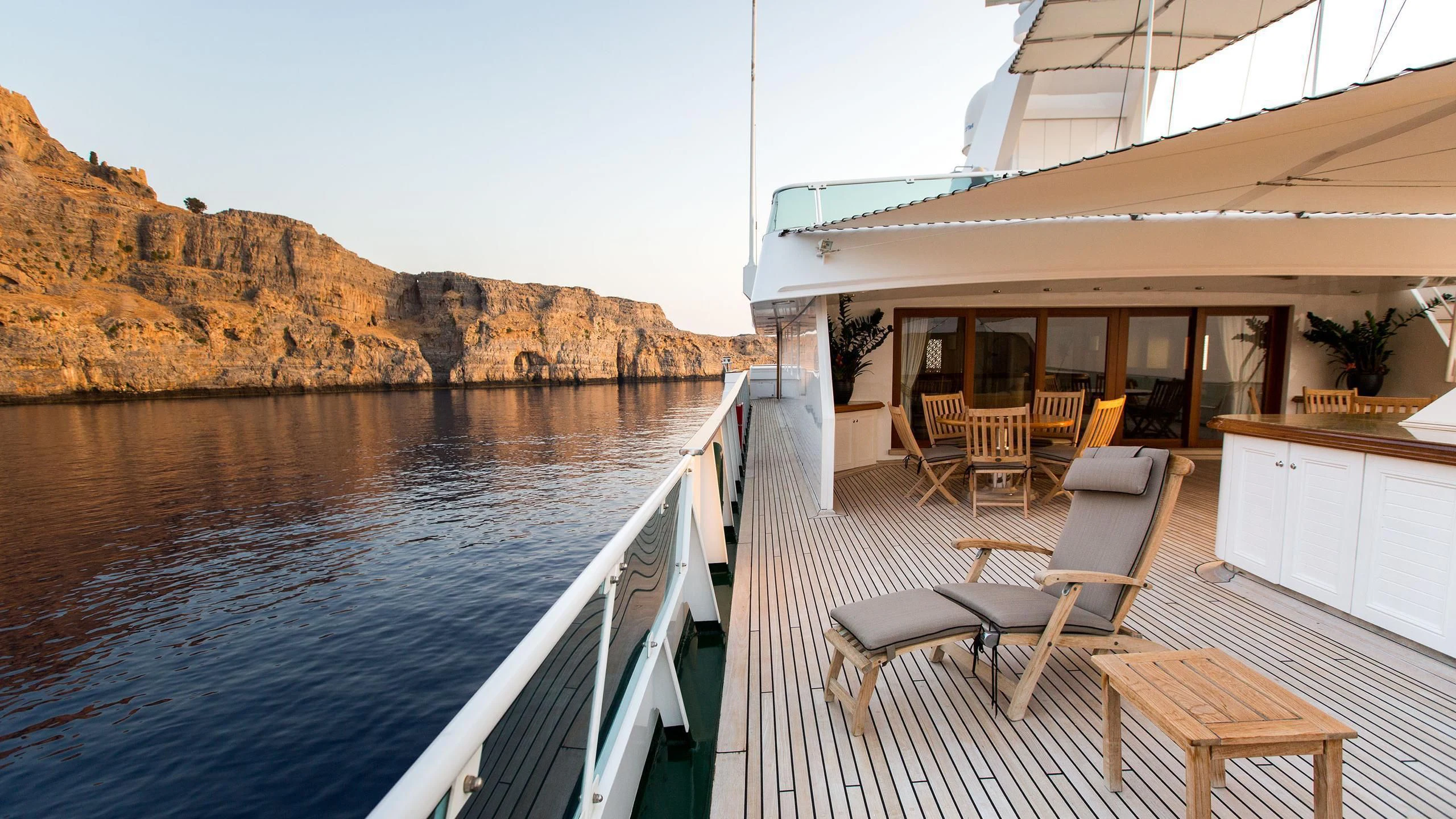 a deck with chairs and tables on it aboard ESMERALDA Yacht for Sale