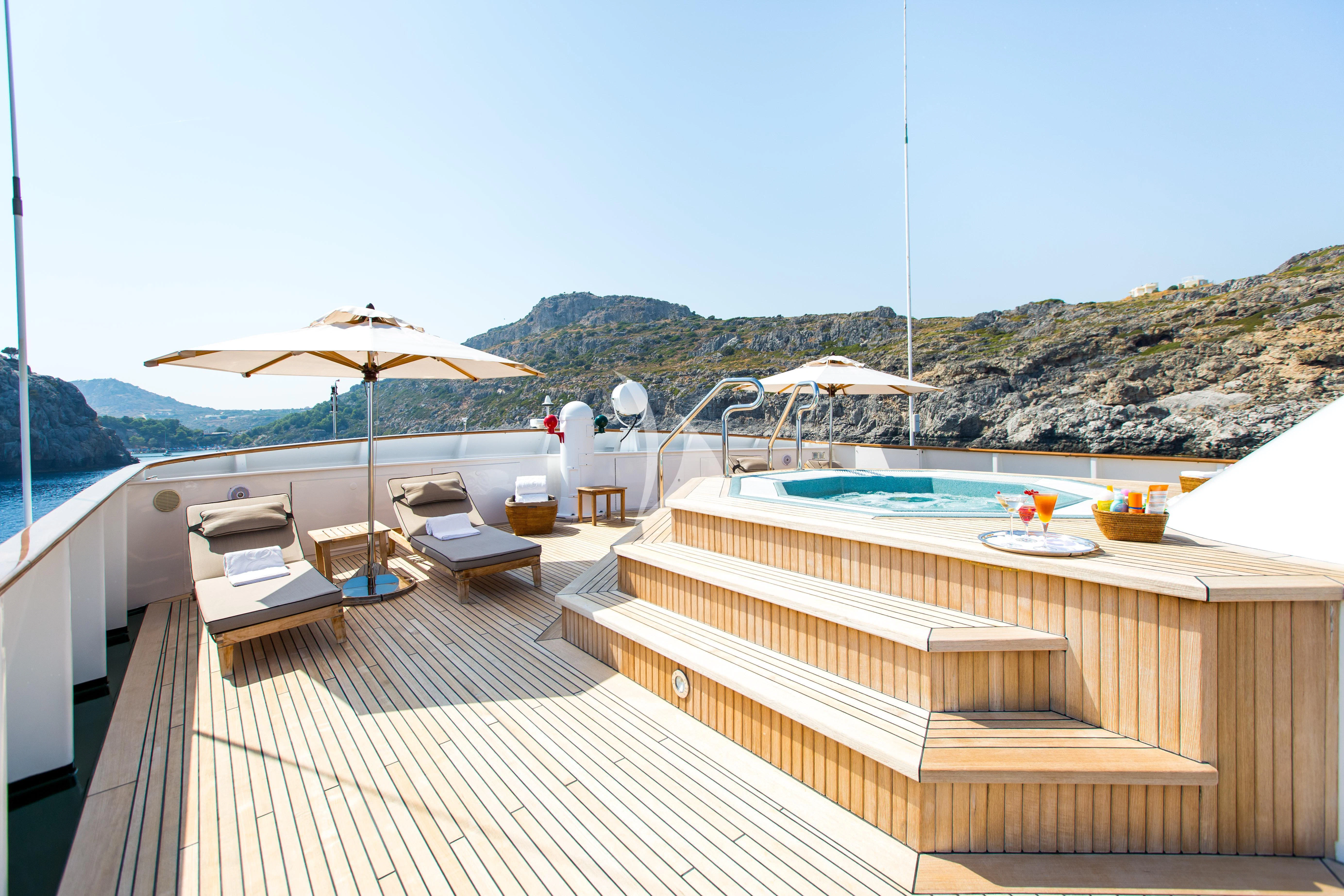 a pool with a deck and umbrellas by a pool aboard ESMERALDA Yacht for Sale