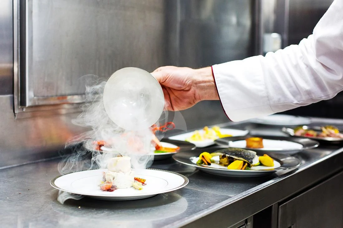 chef preparing food on a table aboard ESMERALDA Yacht for Sale