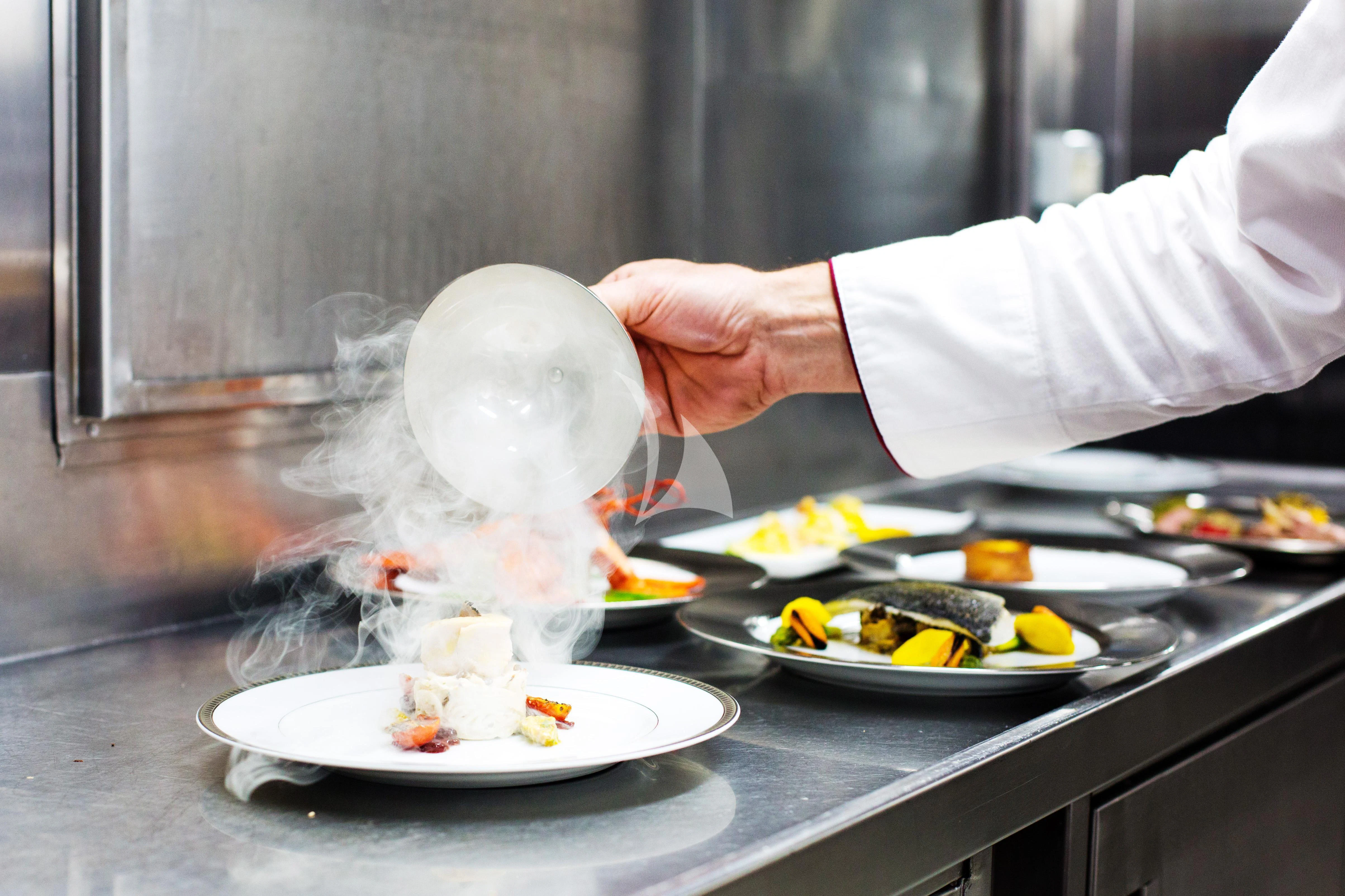 chef preparing food on a table aboard ESMERALDA Yacht for Sale