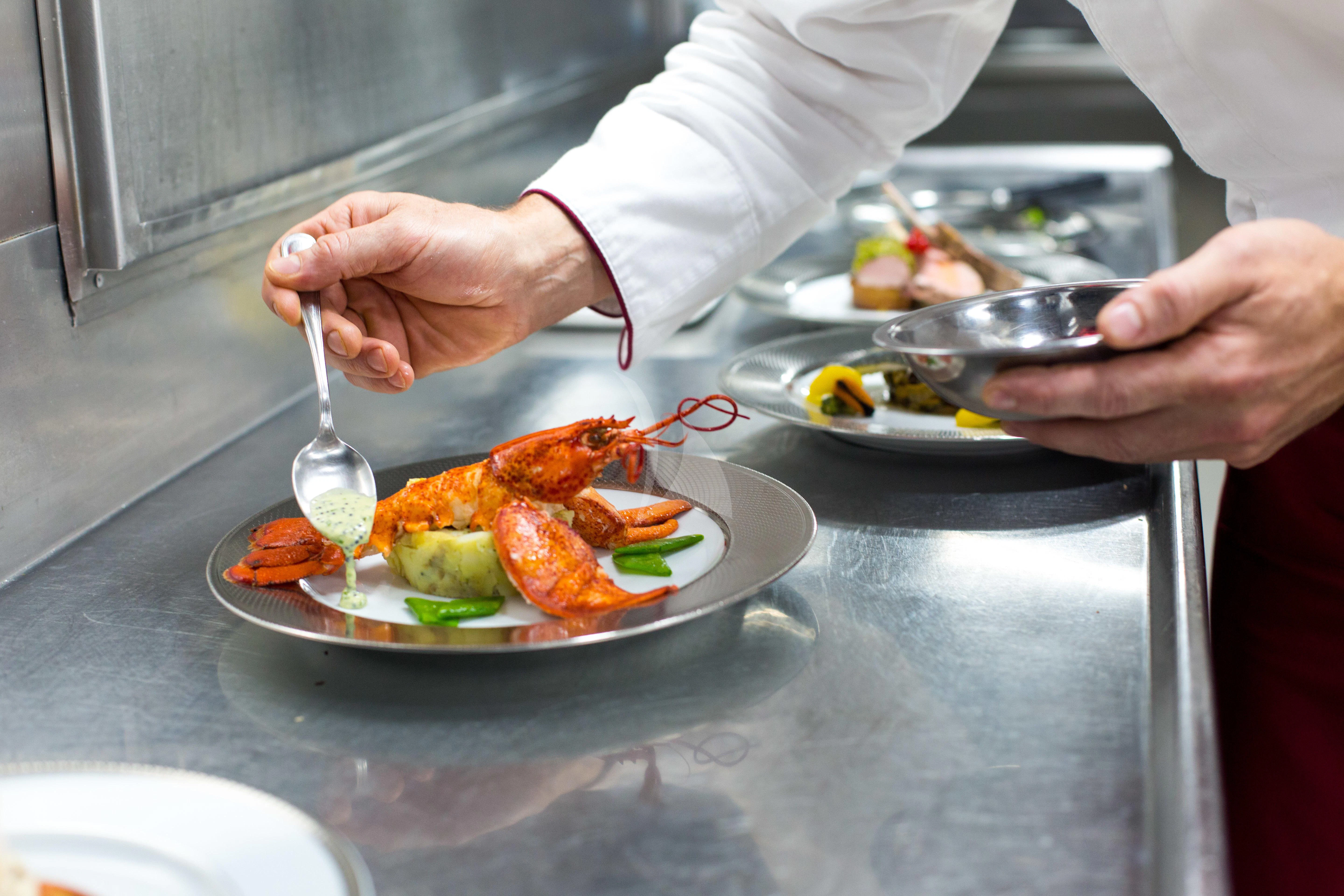 a person preparing food on a plate aboard ESMERALDA Yacht for Sale