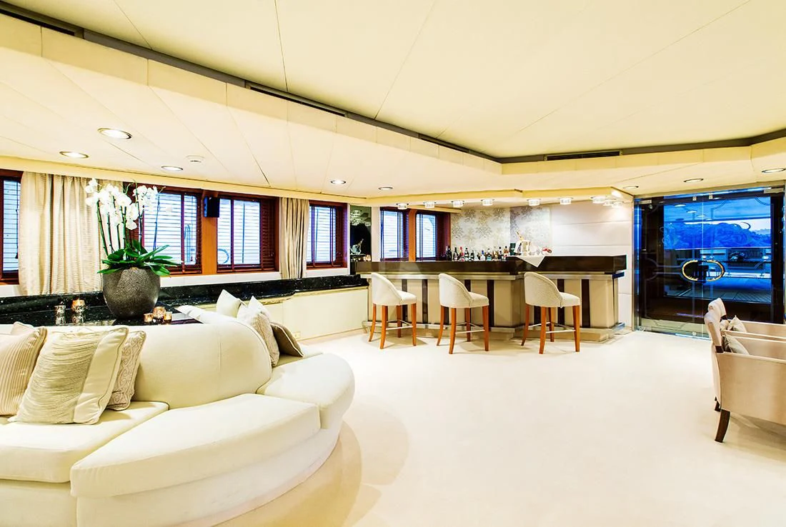 a large living room with white furniture aboard ESMERALDA Yacht for Sale