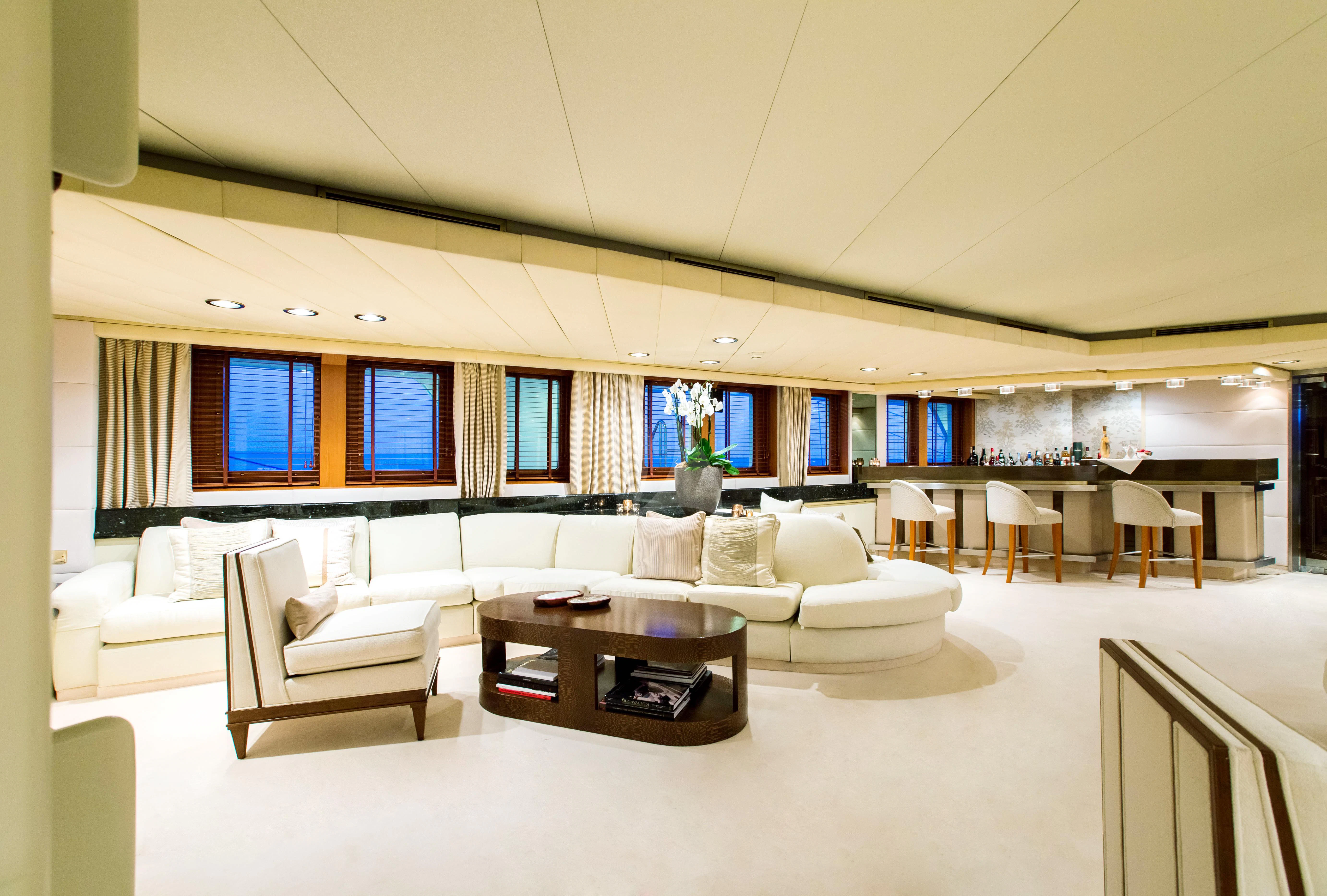 a large room with white furniture aboard ESMERALDA Yacht for Sale