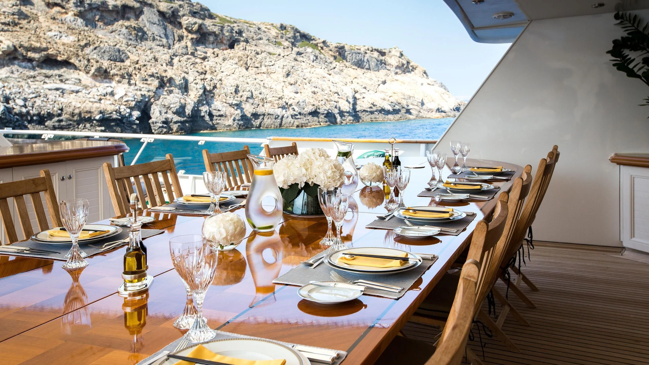 a table set with plates and glasses aboard ESMERALDA Yacht for Sale