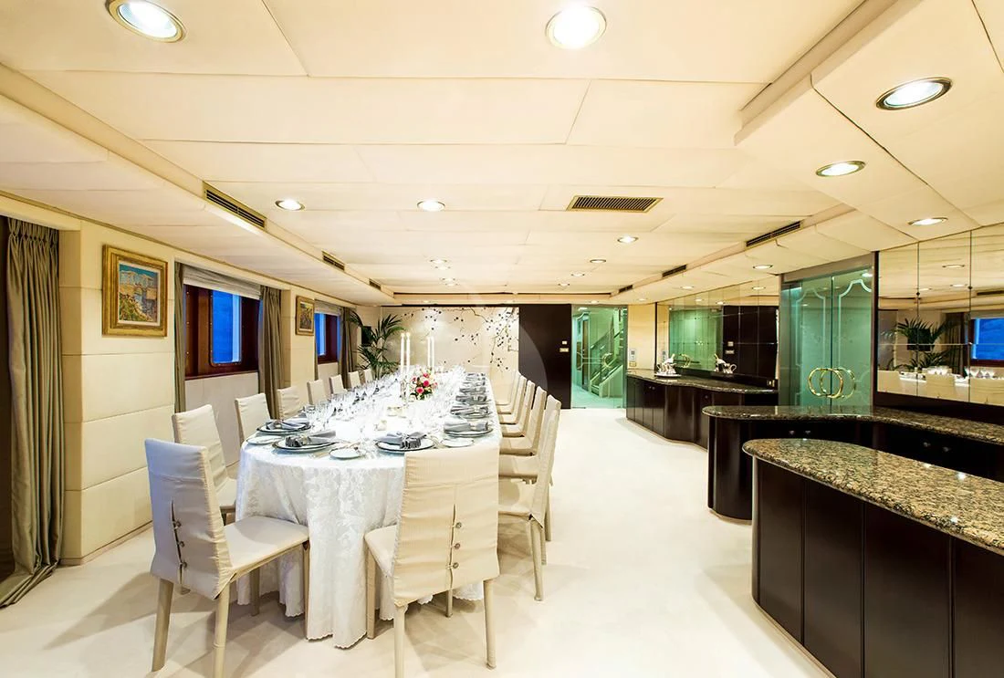 a large room with tables and chairs aboard ESMERALDA Yacht for Sale