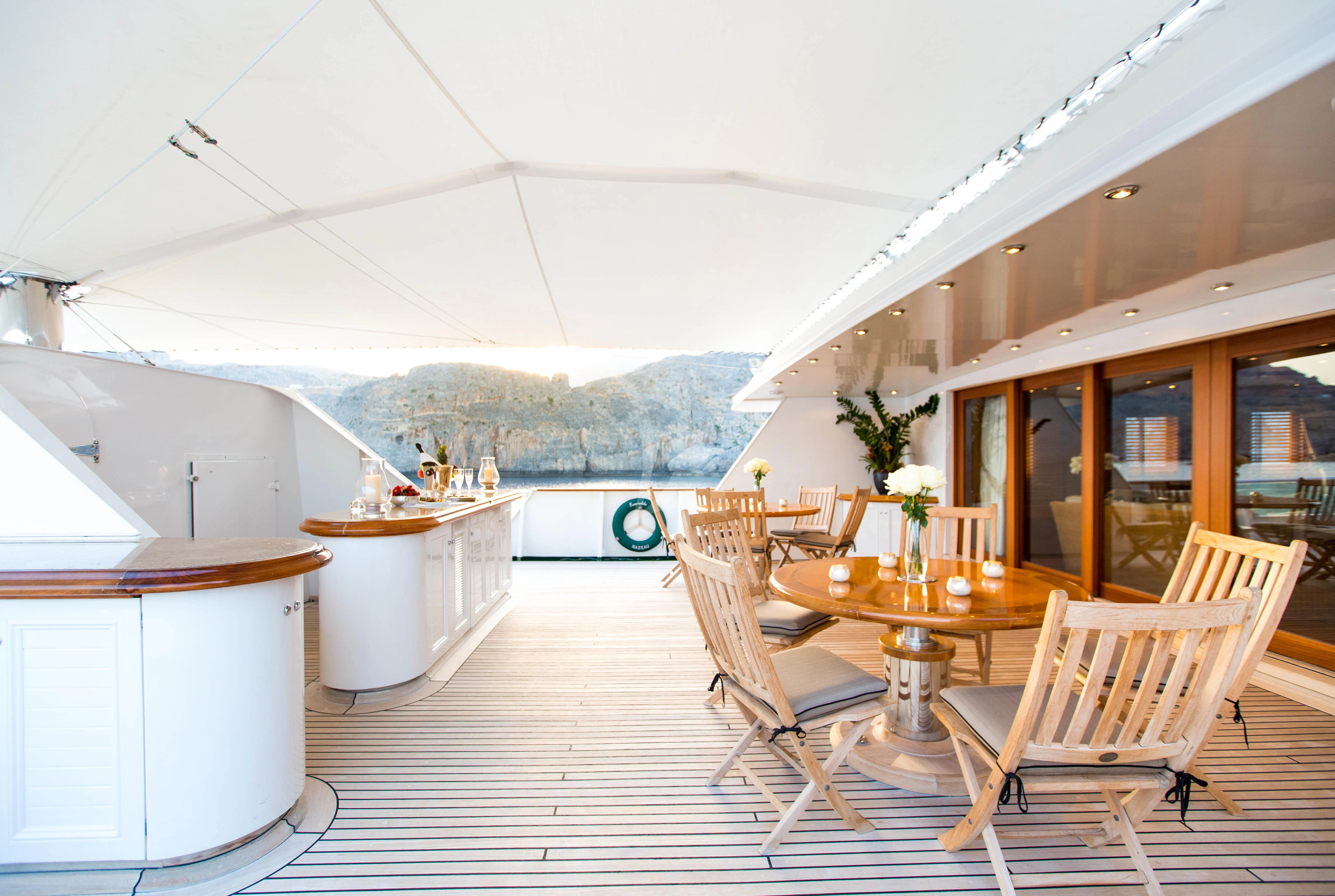 a room with tables and chairs aboard ESMERALDA Yacht for Sale