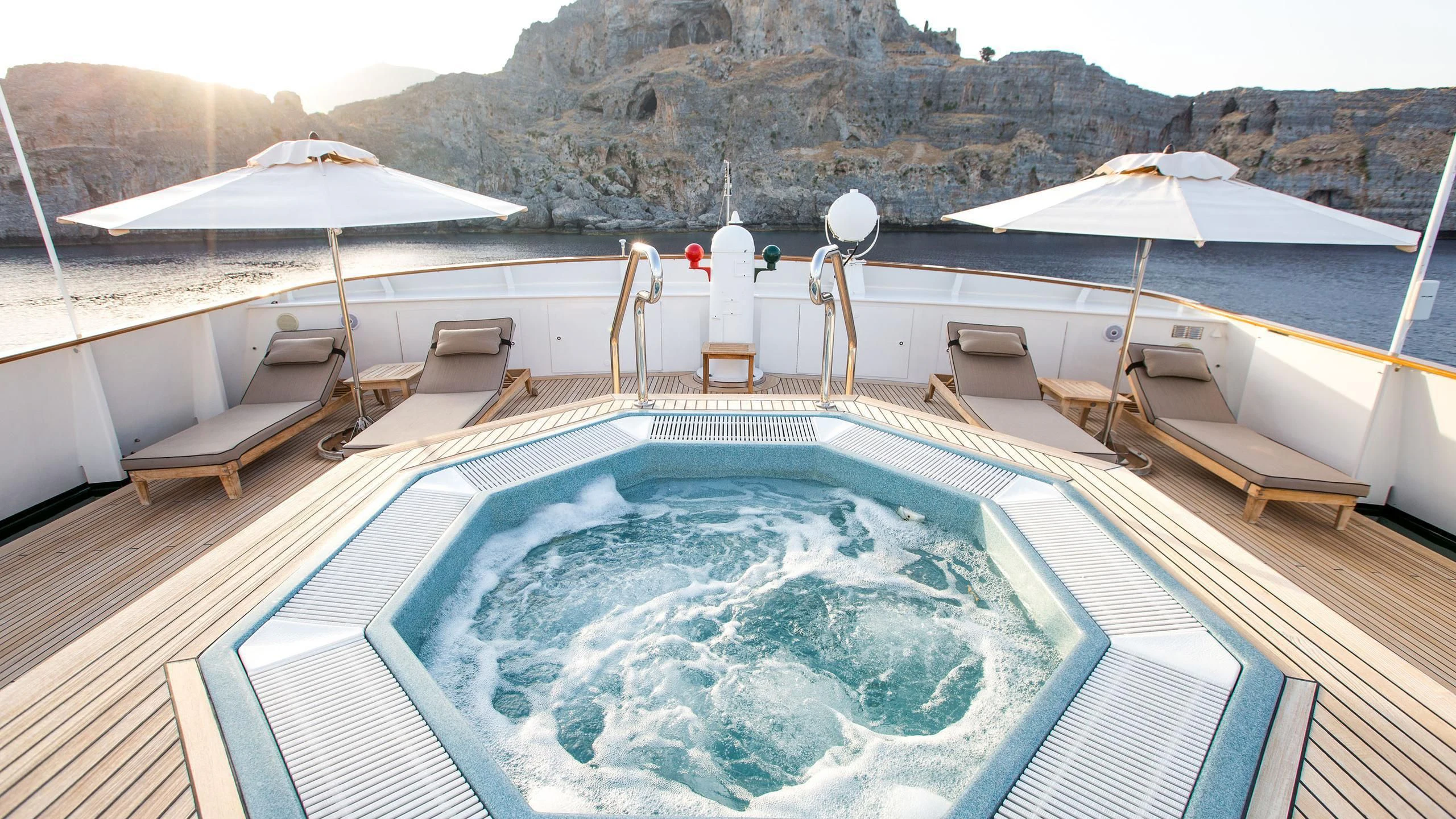 a swimming pool with lounge chairs and umbrellas aboard ESMERALDA Yacht for Sale