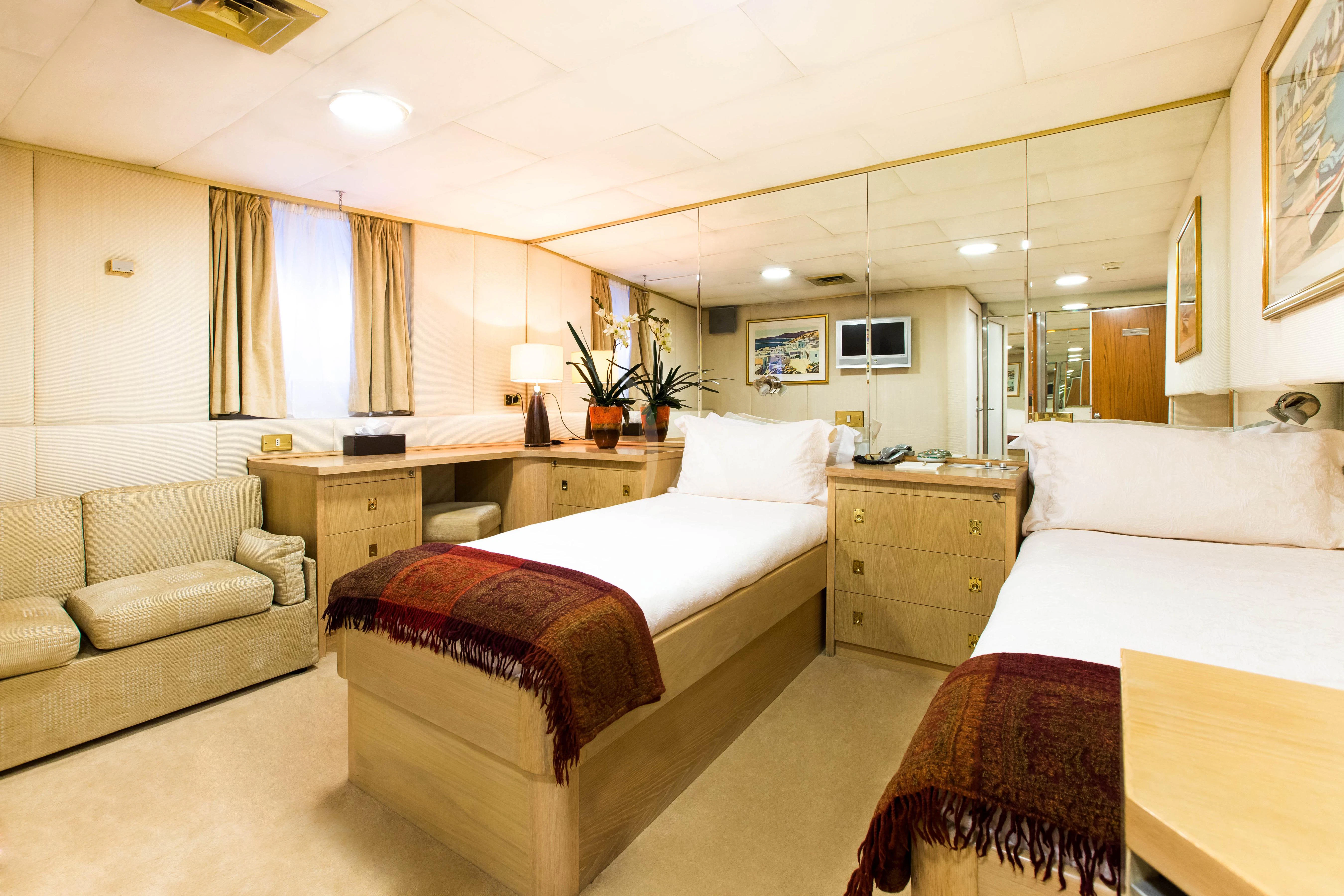 a room with two beds and a couch aboard ESMERALDA Yacht for Sale