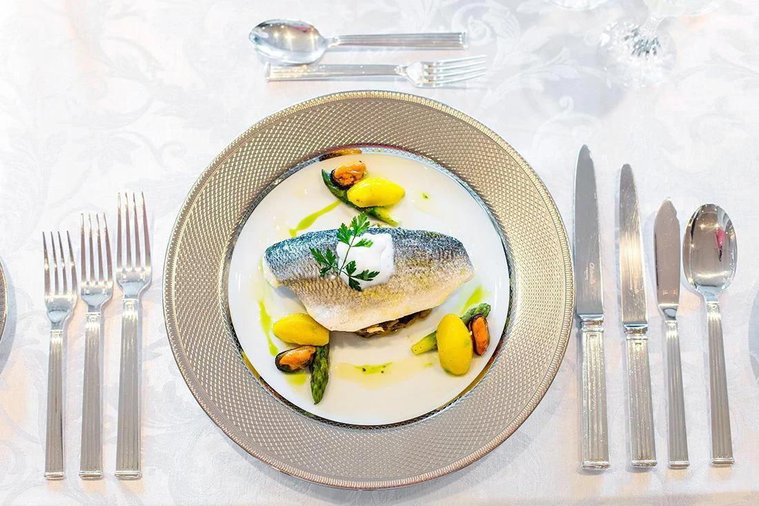 a plate of food and silverware aboard ESMERALDA Yacht for Sale