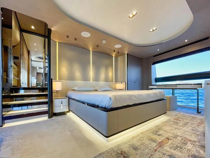 a large bedroom with a balcony aboard WAVE Yacht for Sale