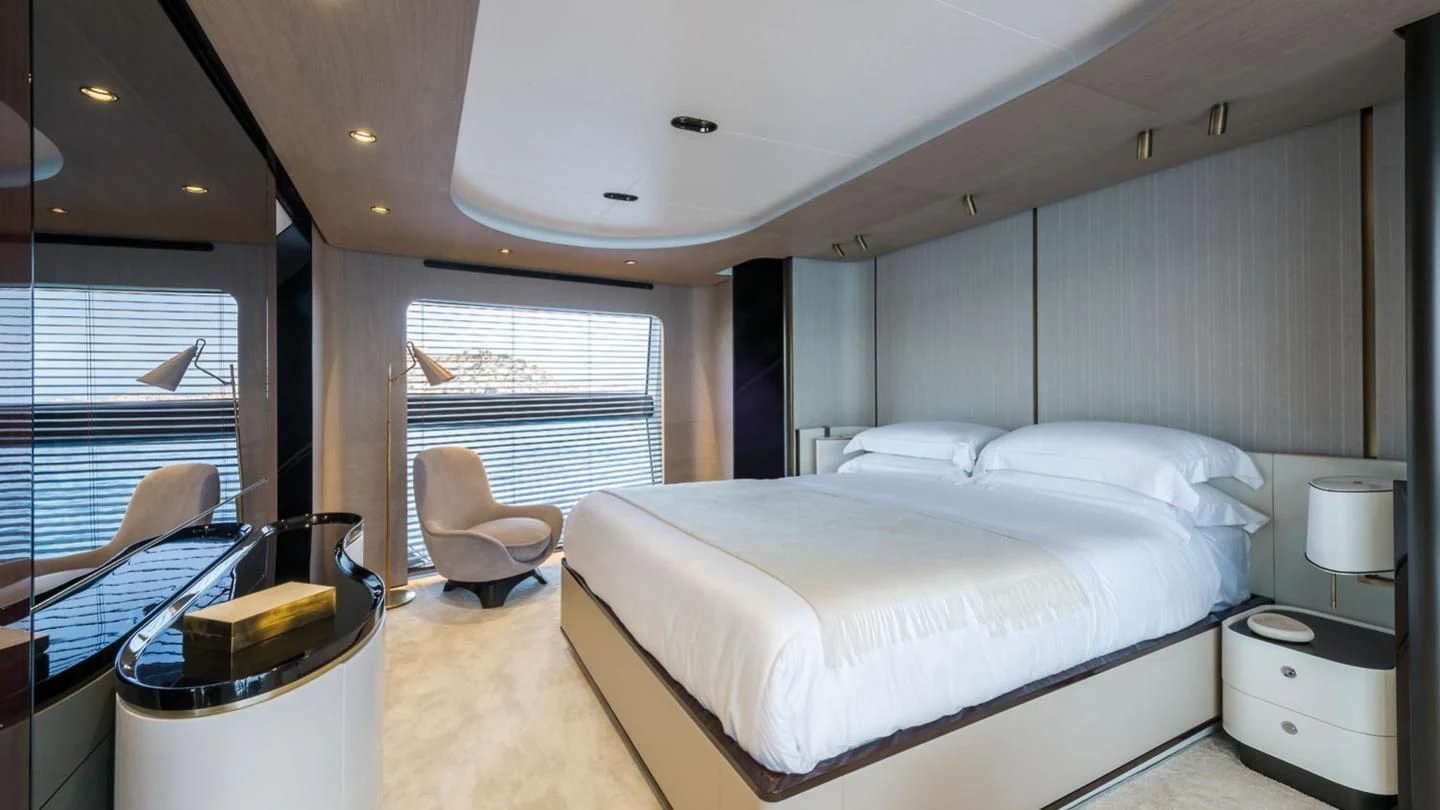 a bedroom with a bed and a desk aboard WAVE Yacht for Sale
