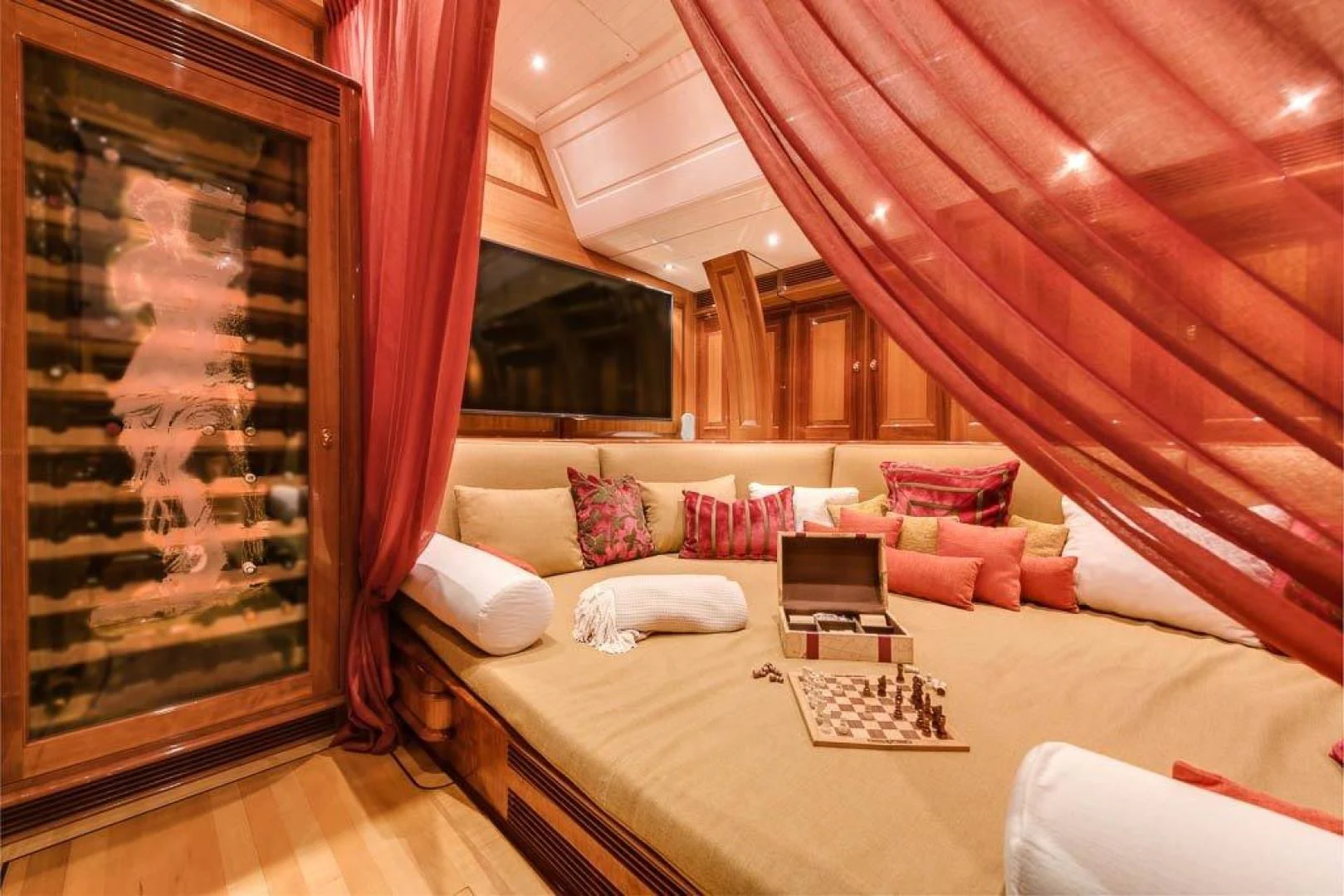 a bed with a red curtain aboard DELUSHA Yacht for Sale