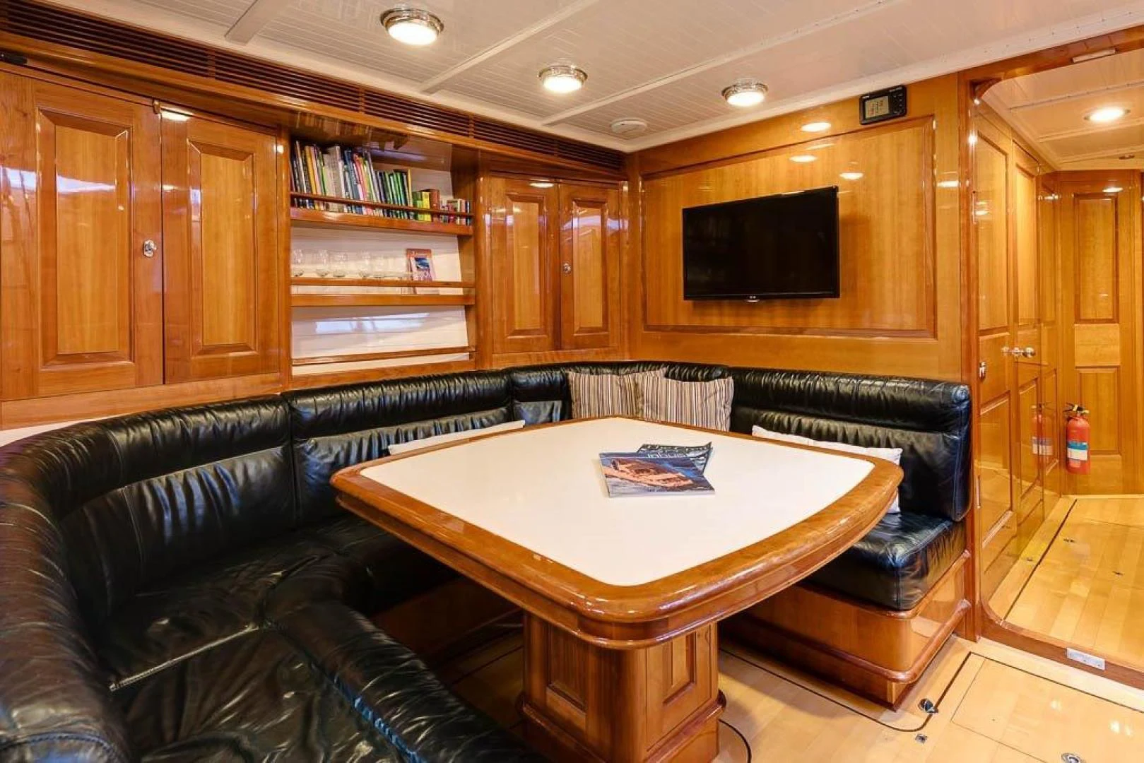 a living room with a black couch and a television aboard DELUSHA Yacht for Sale