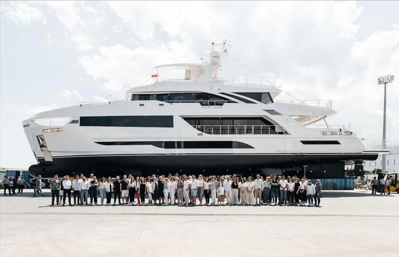a group of people standing in front of a large ship aboard FAMILIA Yacht for Sale