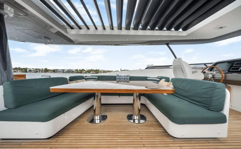 a table and a bench under a covered roof aboard GAS Yacht for Sale
