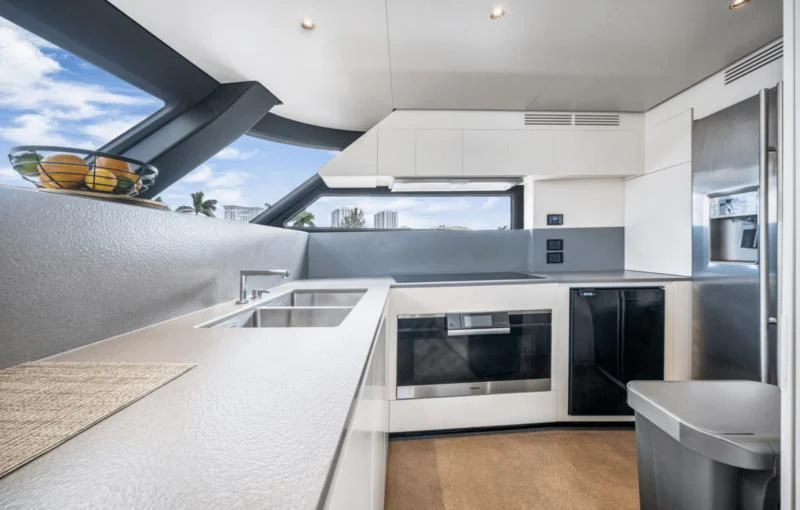 a modern kitchen with white cabinets aboard GAS Yacht for Sale