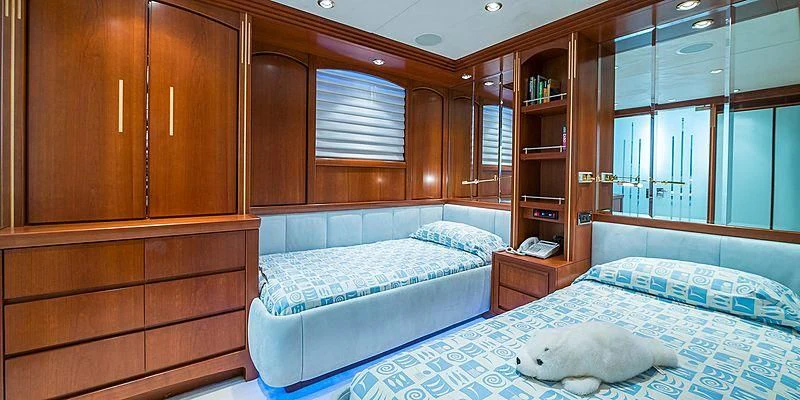 a room with a bed and a shelf with books aboard B5 Yacht for Sale